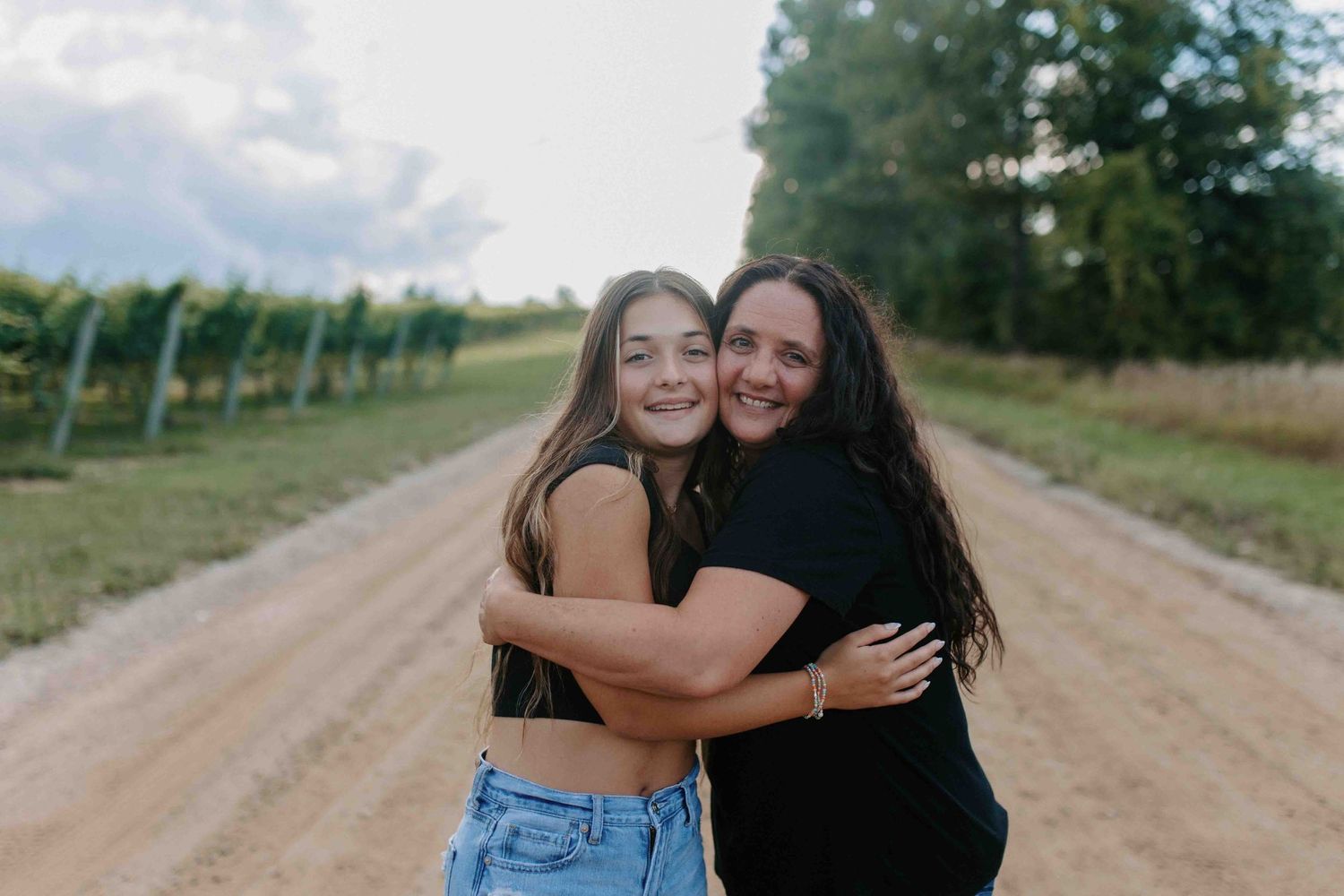 Candid embrace captured during an outdoor photoshoot on a dirt path.