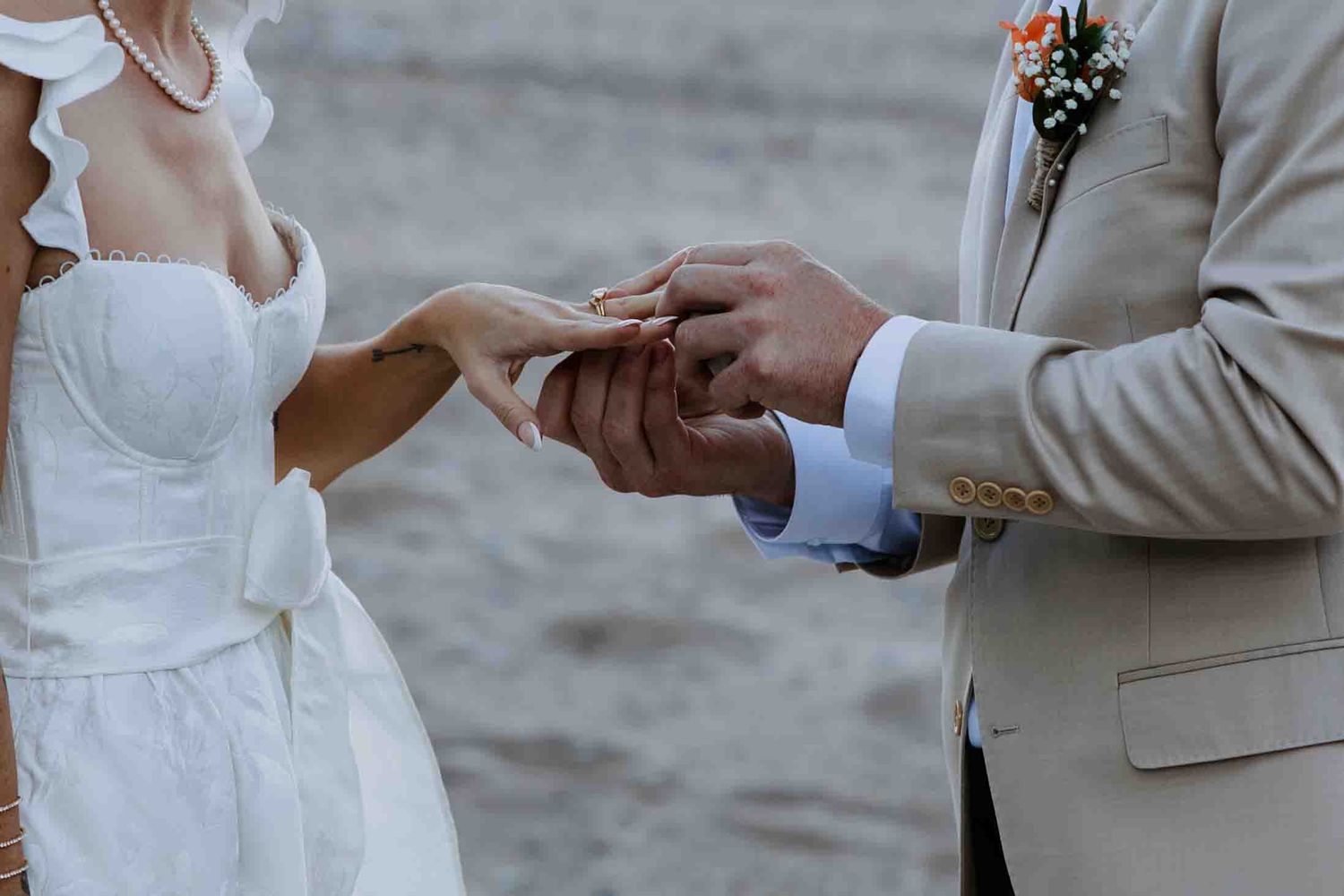 Close-up shots of hands exchanging rings during a beach ceremony.
