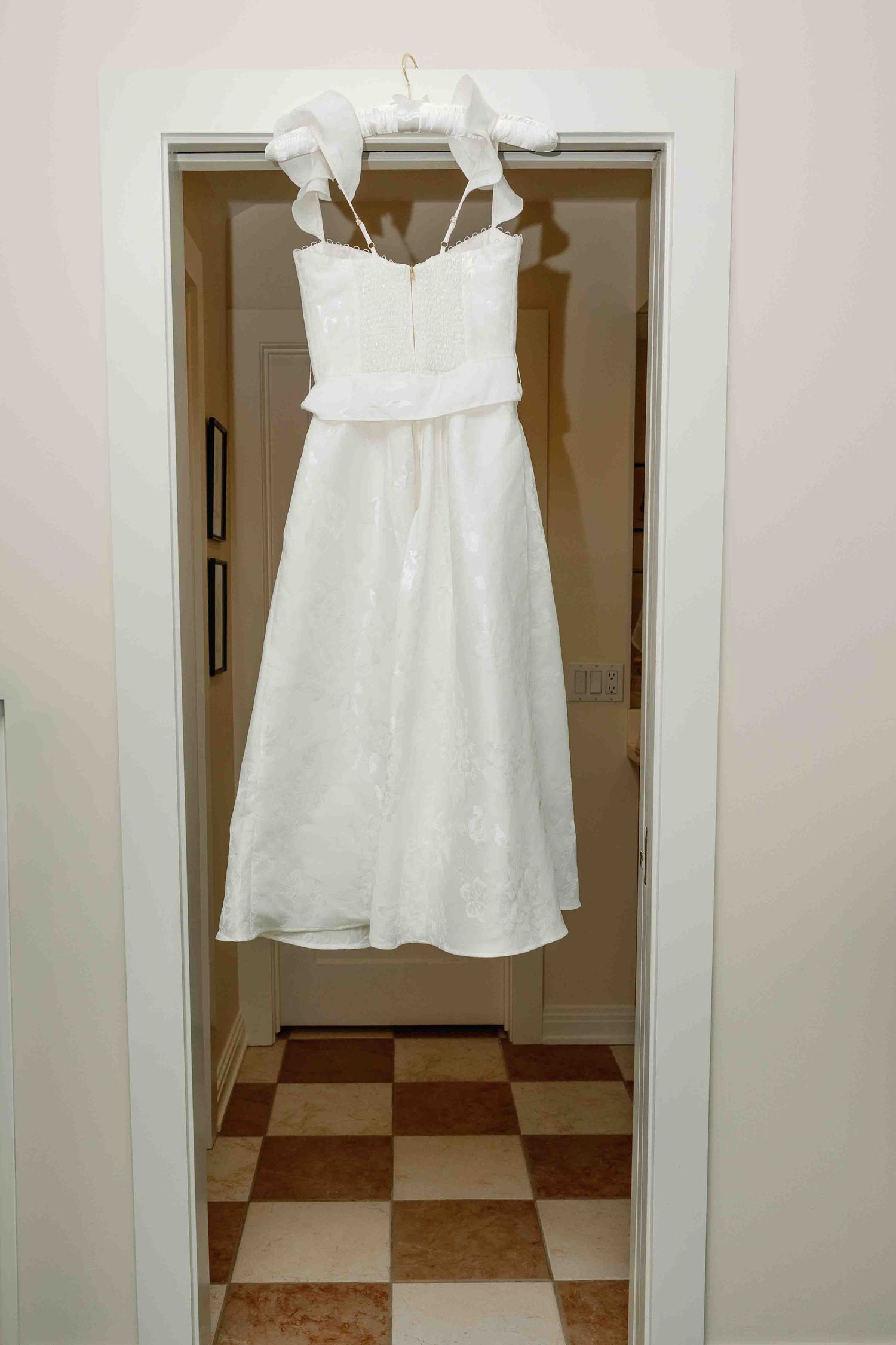 White dress hanging in a hallway shown from multiple angles.