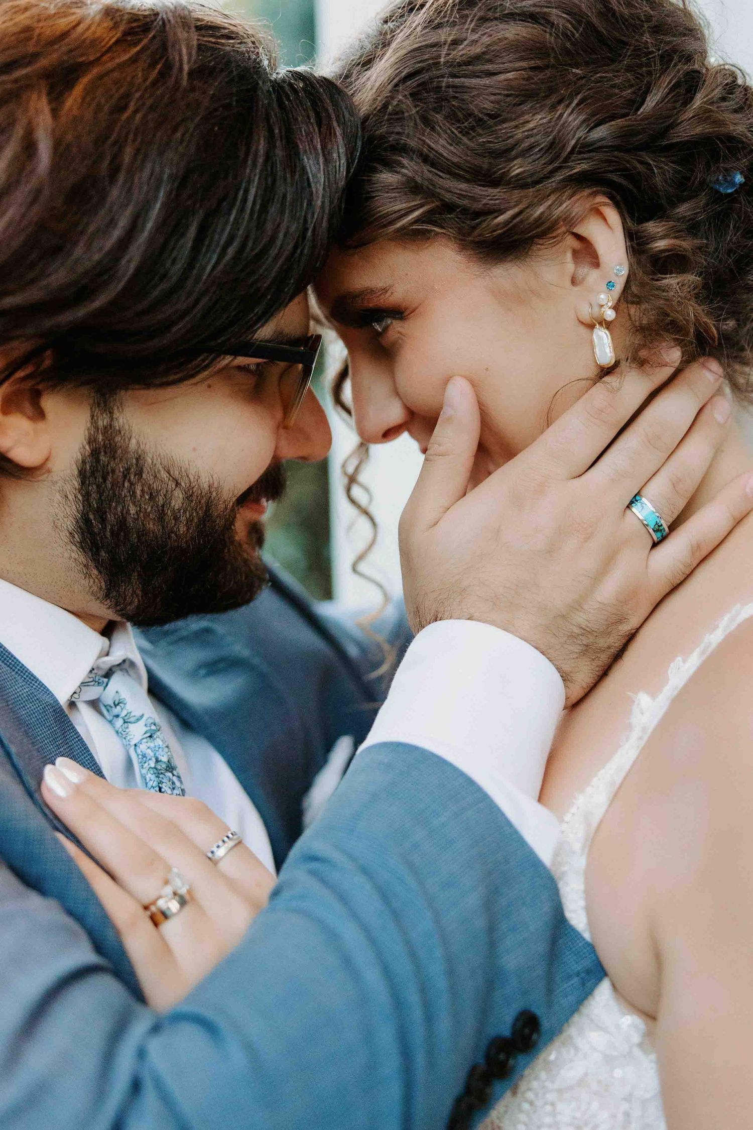 Romantic close-up portrait of a couple sharing an intimate moment in formal wedding attire.