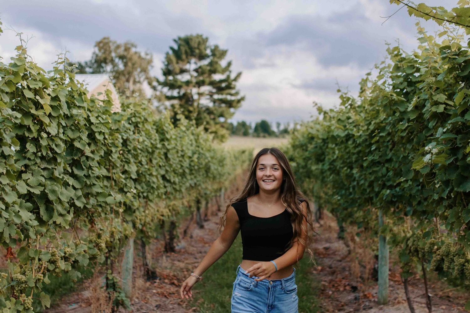 Lifestyle portraits captured among rows of grapevines in a vineyard.