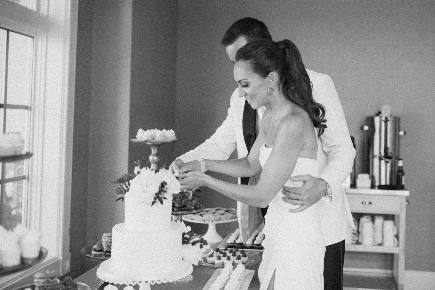 Black and white photo of an elegant wedding reception setup with natural lighting.