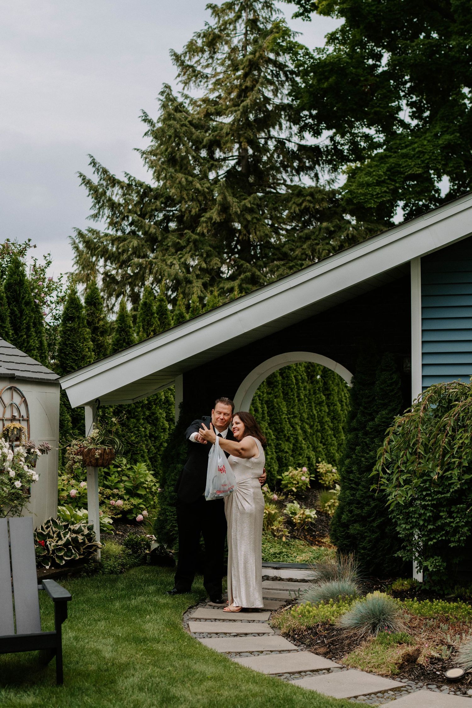Garden wedding venue with white archways and evergreen trees creating a natural backdrop.