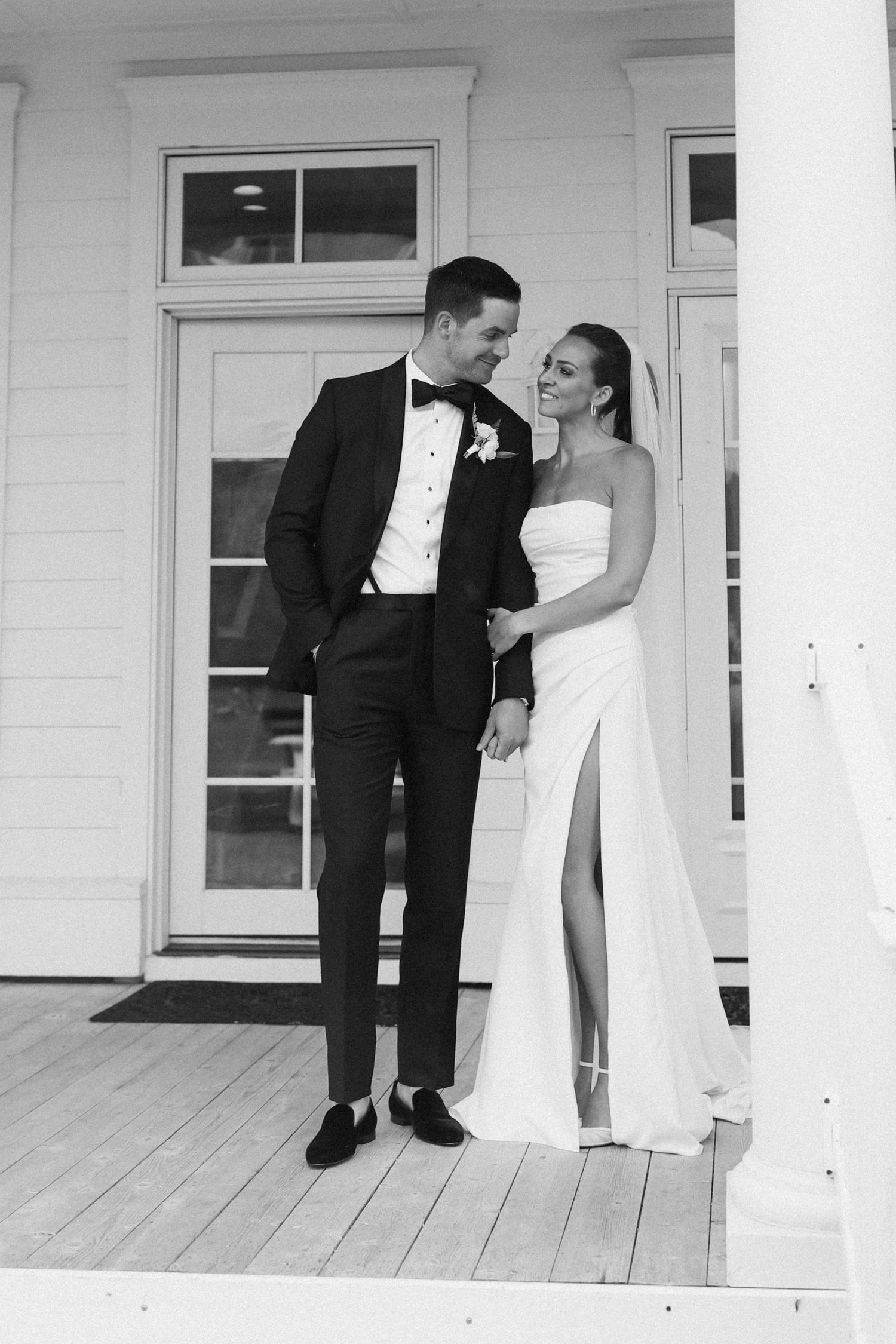 Classic black and white wedding moment on a white porch.