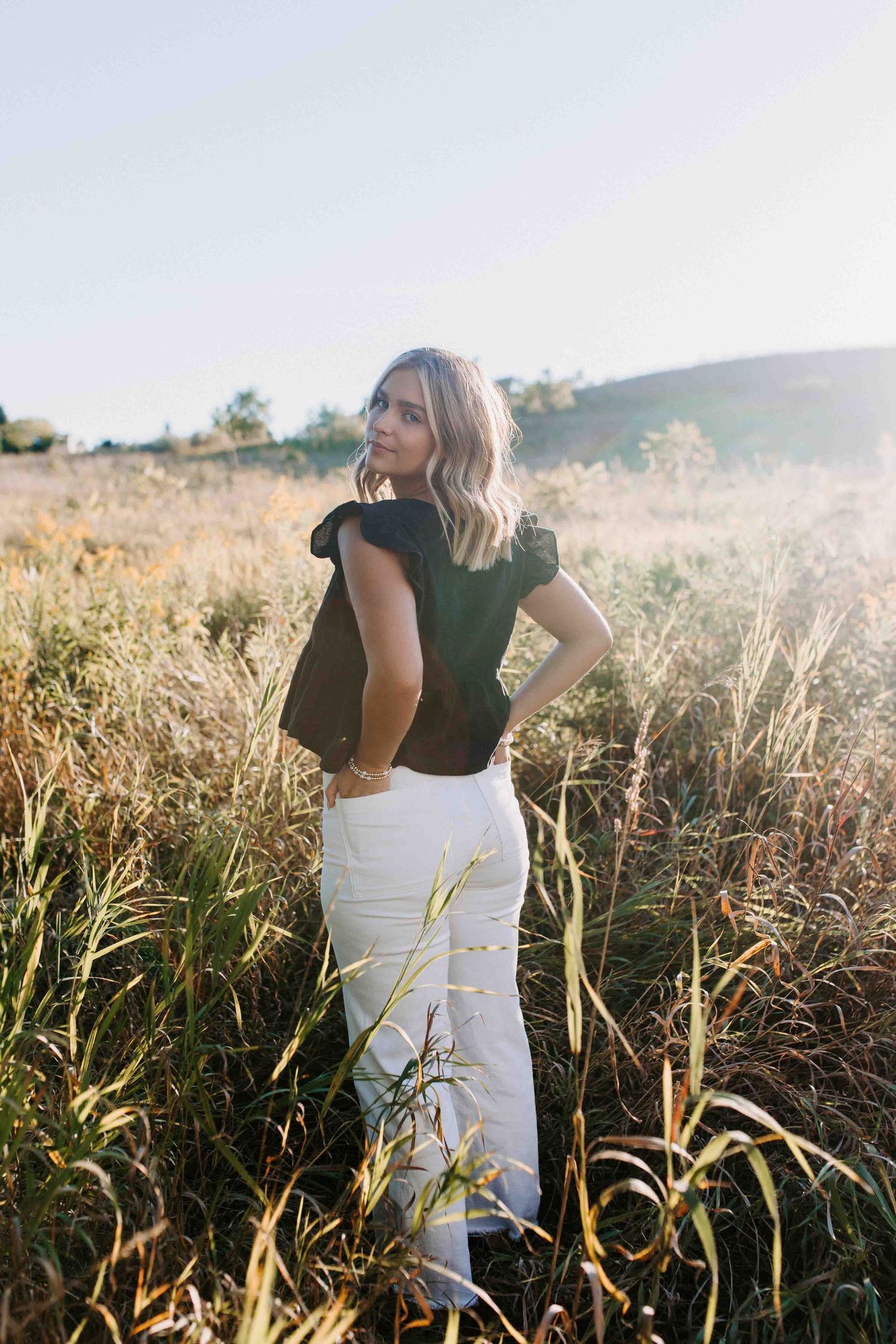 Fashion portraits in tall grass during sunset.