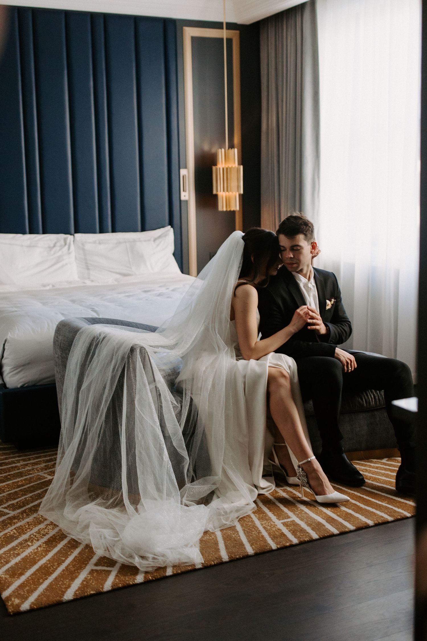 A series of artistic hotel room photos showing a couple in formal attire with flowing white fabric creating dramatic compositions.