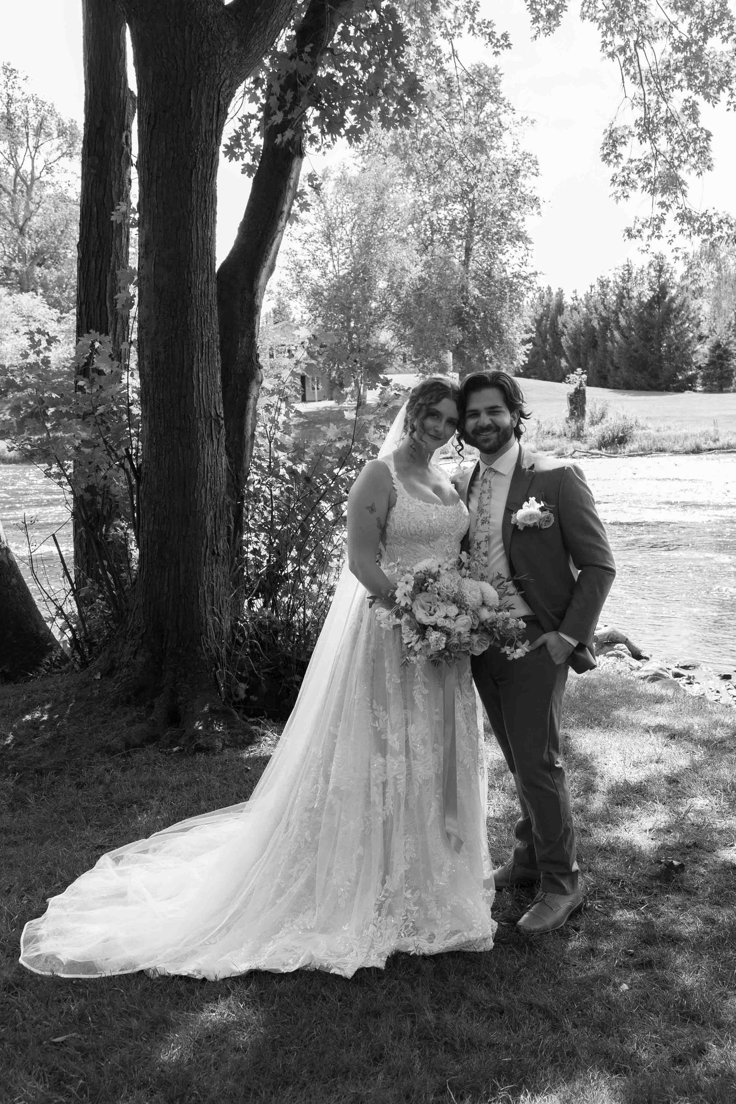 Black and white wedding portraits captured in a scenic outdoor garden setting.
