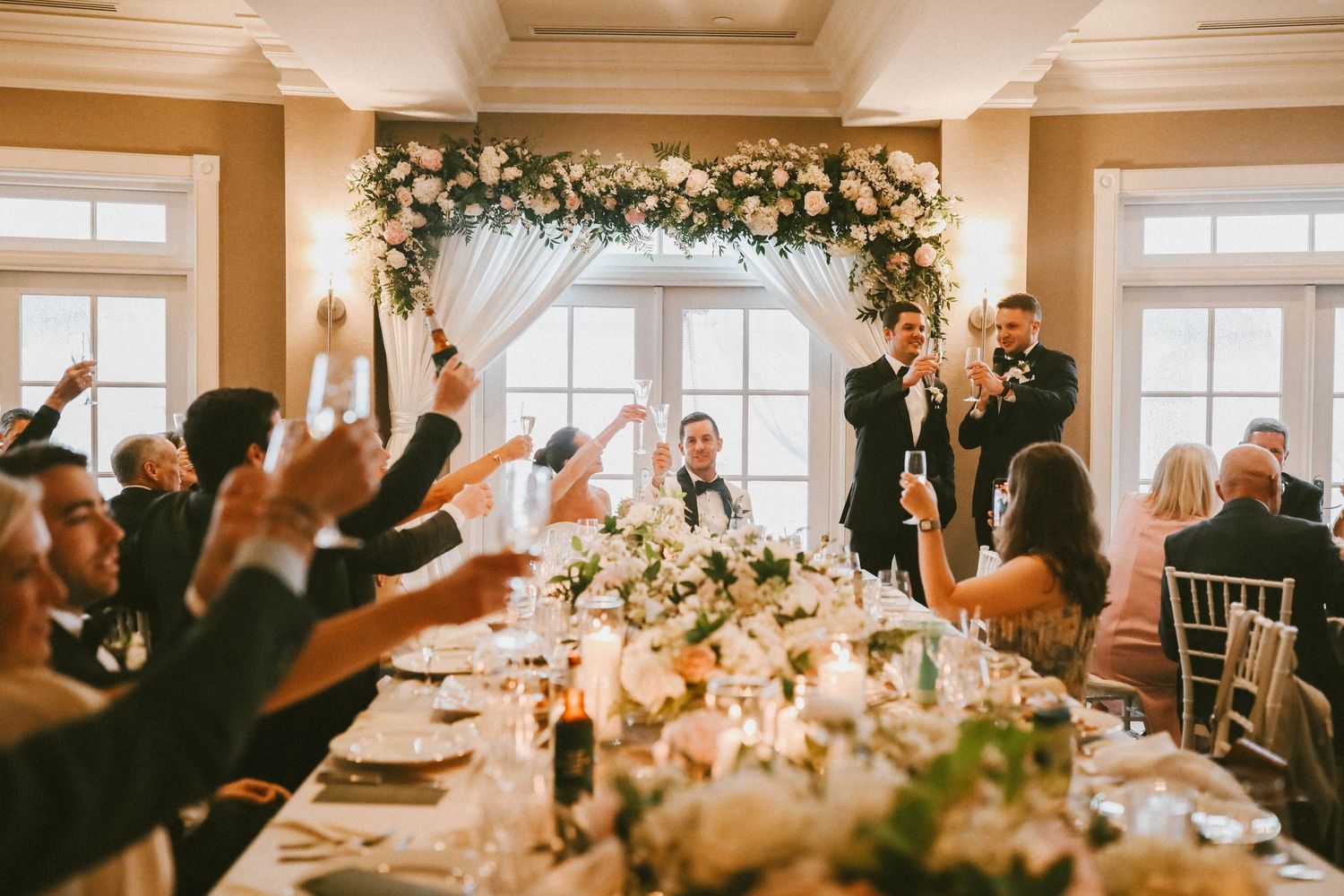 Wedding reception venue decorated with floral arrangements and warm lighting for evening celebrations.