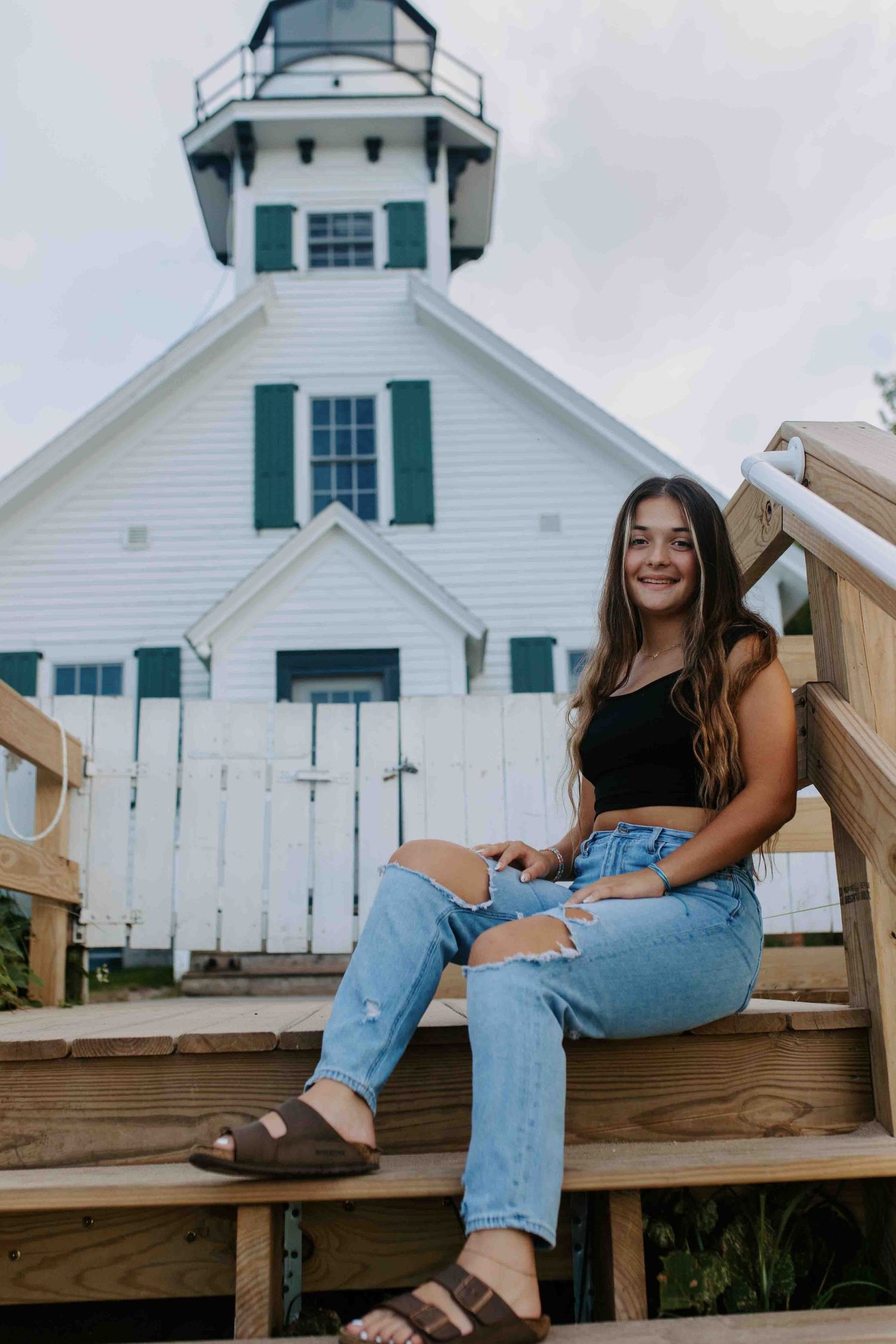 Portrait session at lighthouse featuring wooden deck and casual summer style.