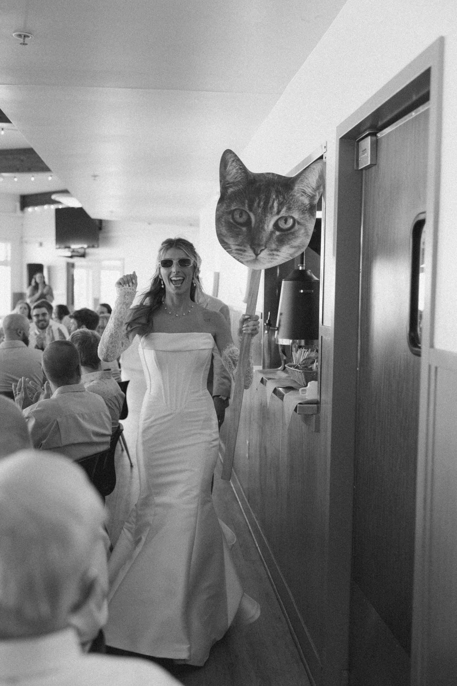 Wedding party walking down a bright hallway with interior doors.