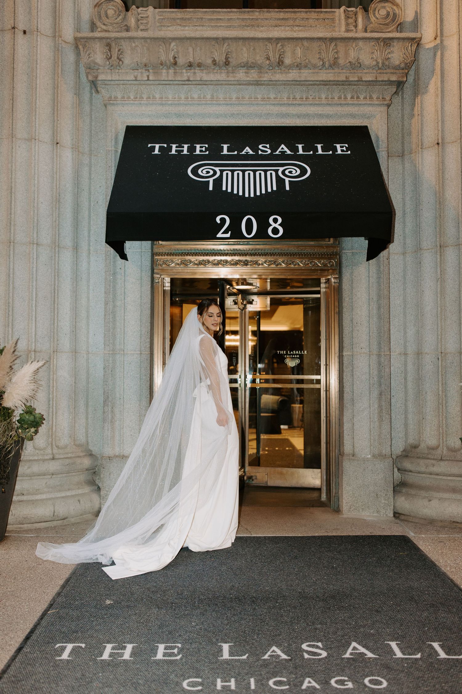 Wedding couple portraits outside The LaSalle Chicago hotel entrance with flowing veil details.