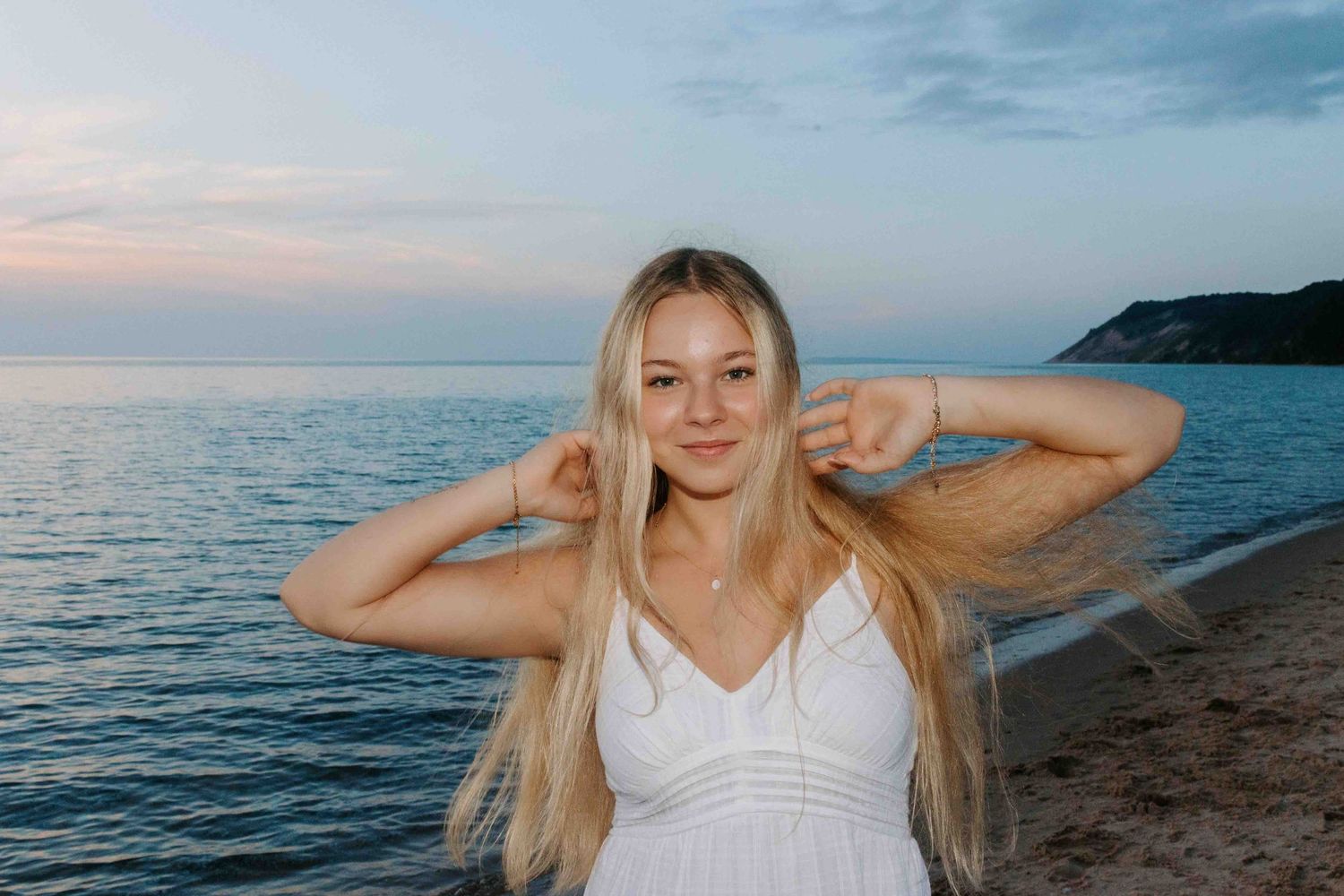 Beachside portrait session during golden hour with waves and cliffs in background.