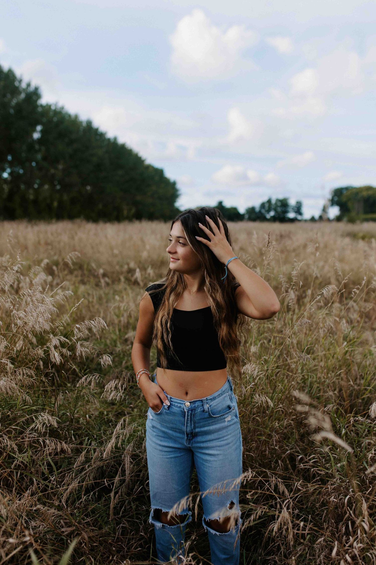 Lifestyle portrait in tall grass field with casual summer outfit.