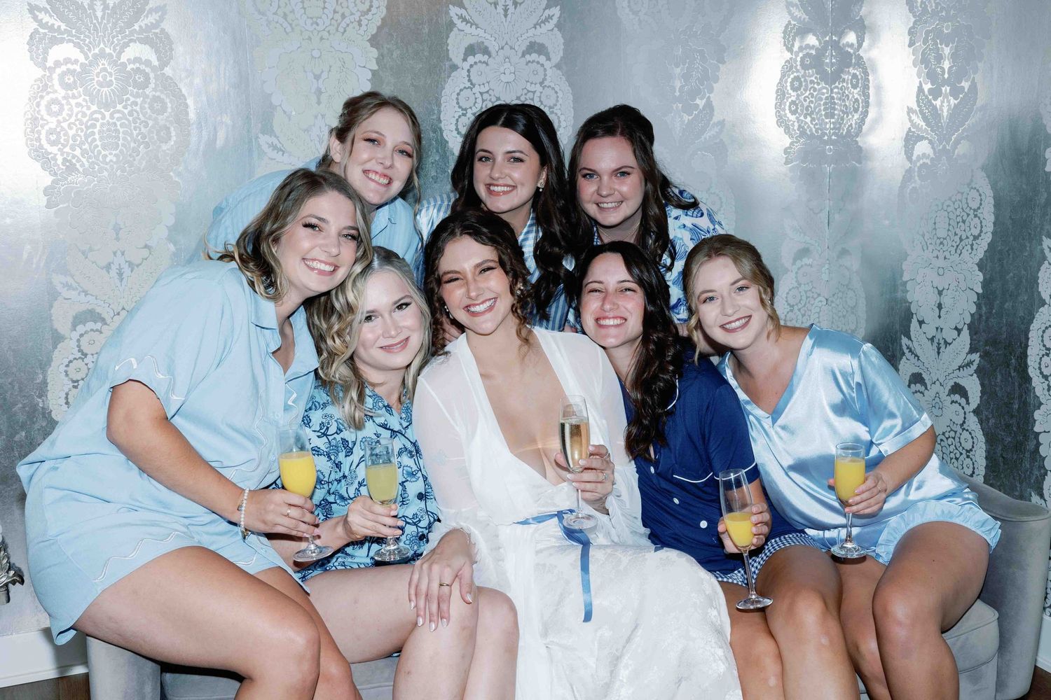 Wedding party in light blue dresses posing together for group photos.