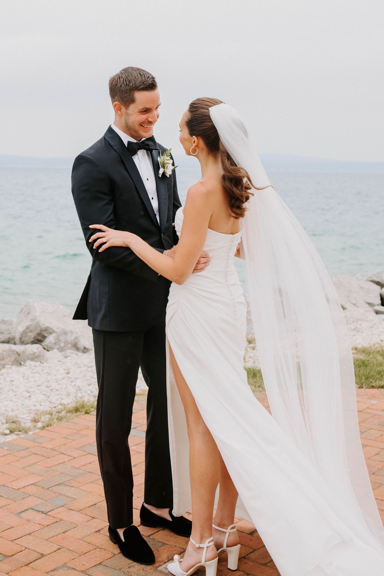 Bride and groom share emotional first look reactions by the waterfront.