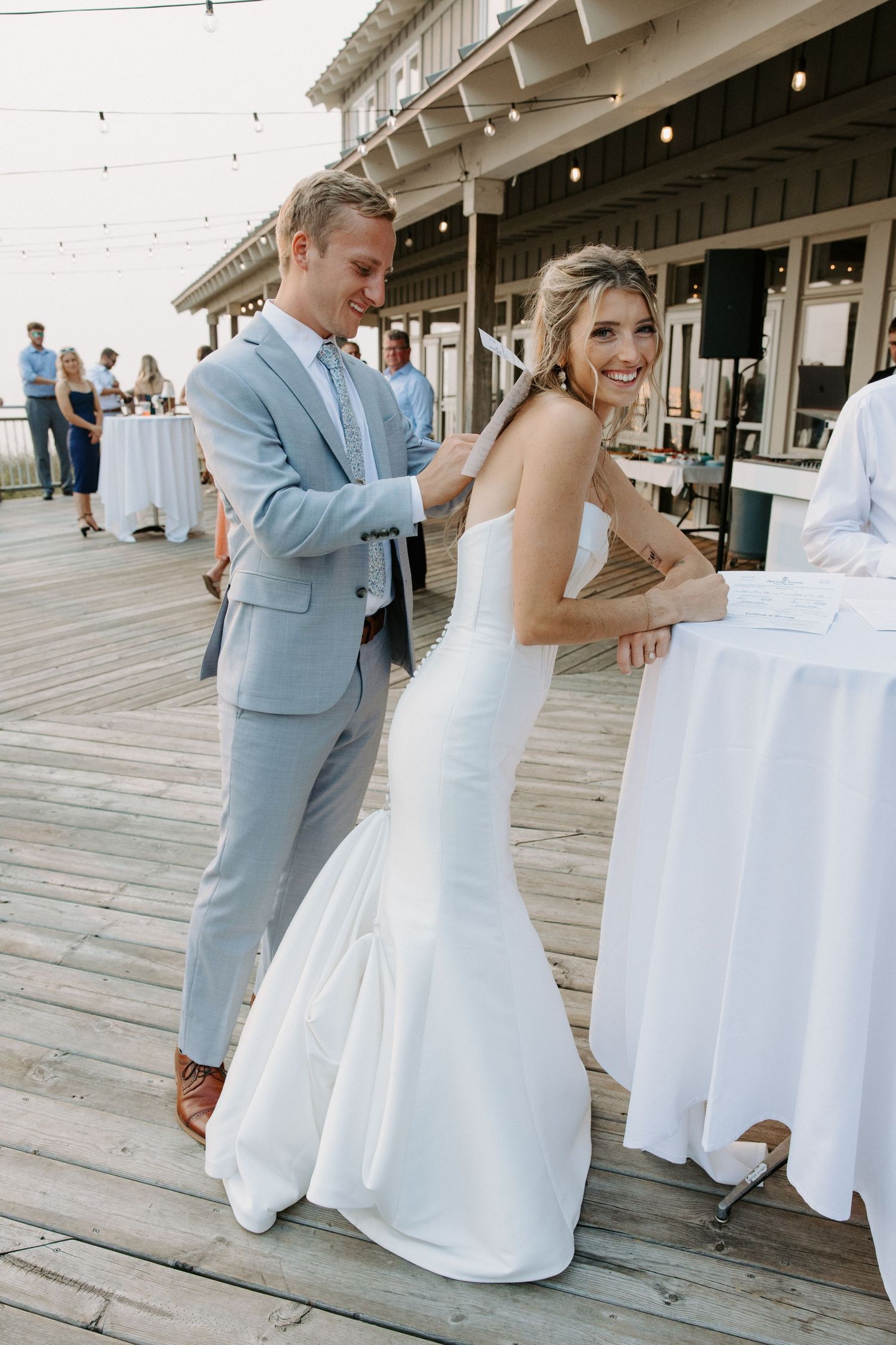 Wedding couple dancing and twirling on a wooden deck during their celebration.