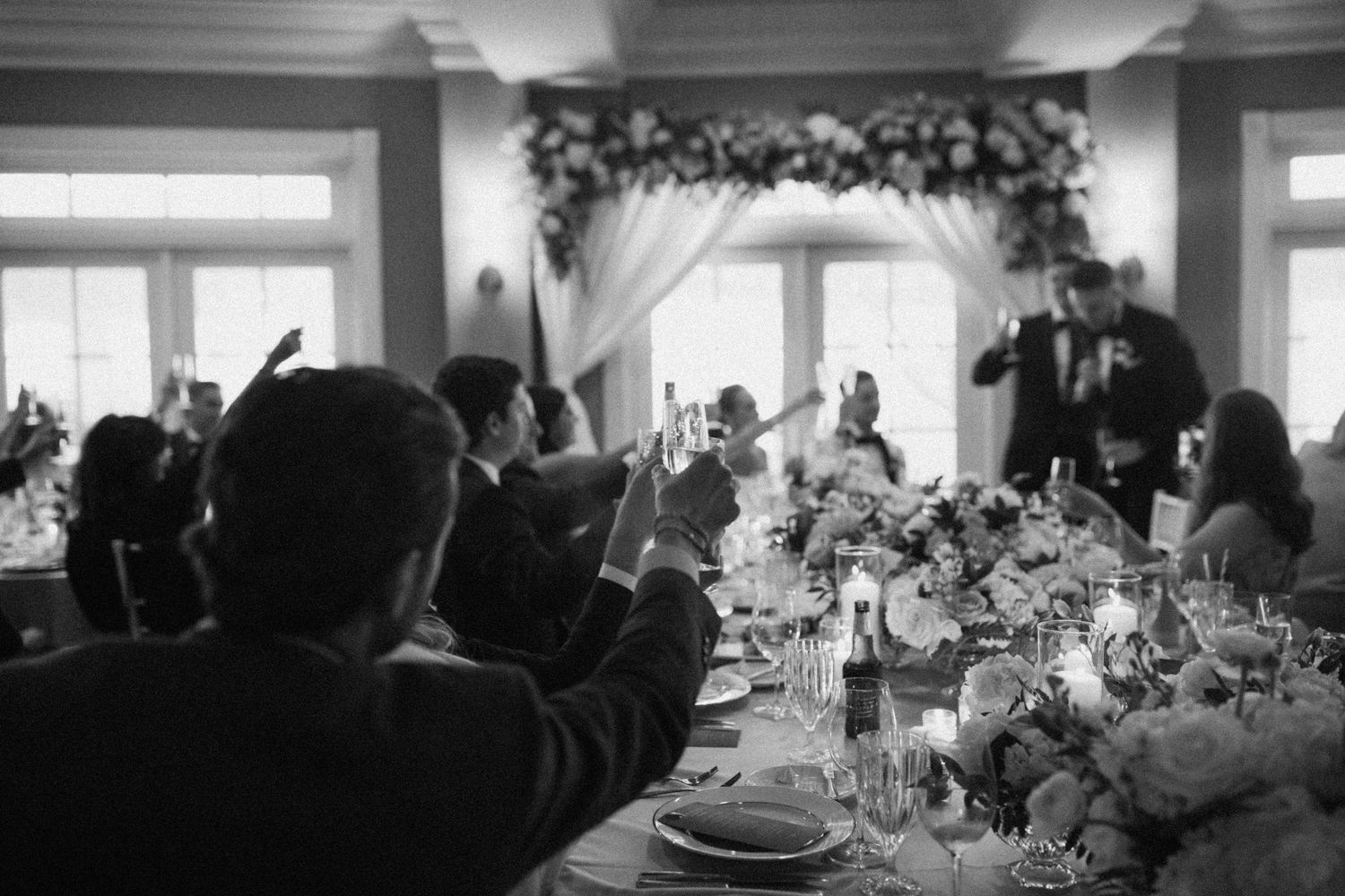 Panoramic view of a wedding venue with floral arrangements and white table settings.