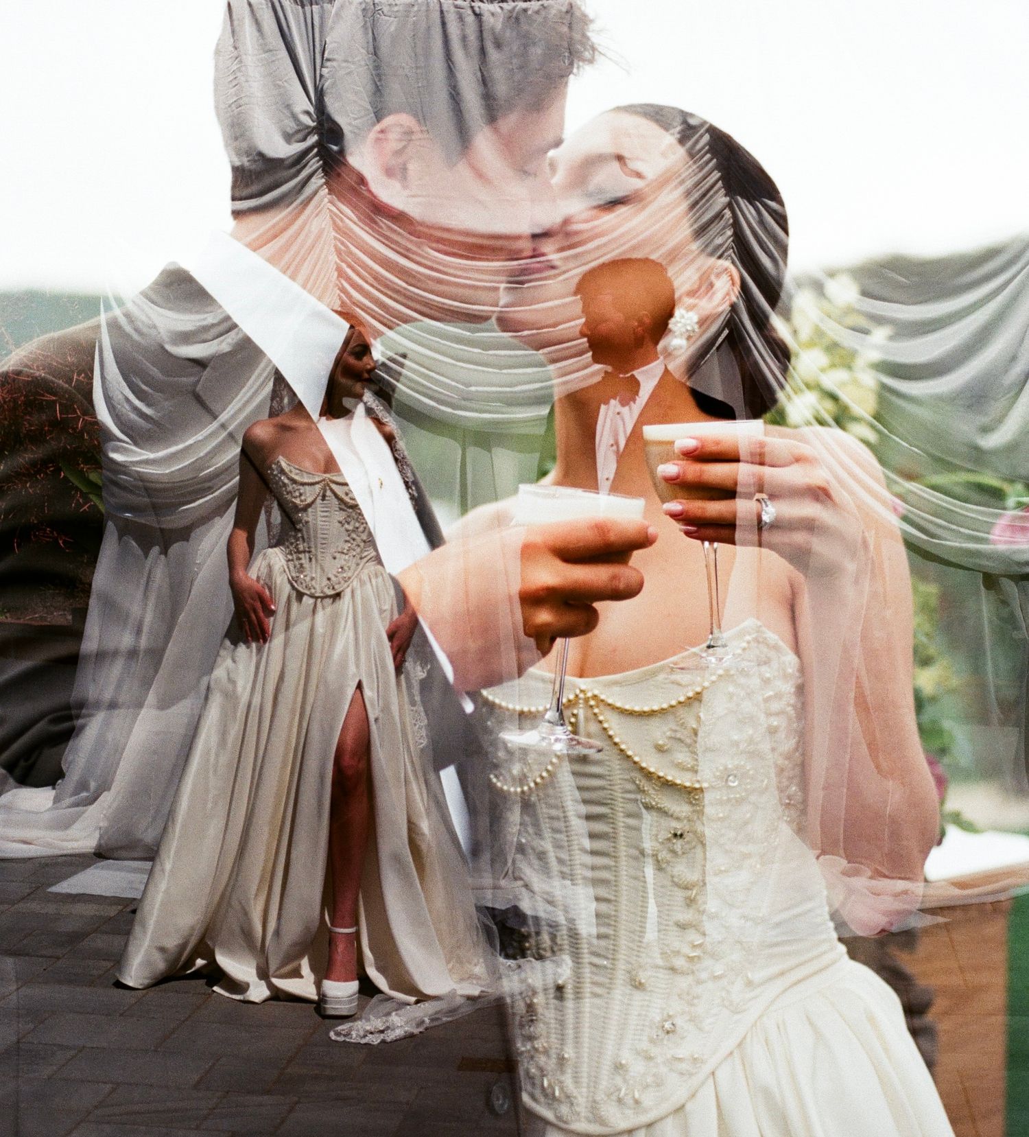 A couple in wedding attire share a toast with drinks while surrounded by flowing fabric and bridesmaids in soft lighting.