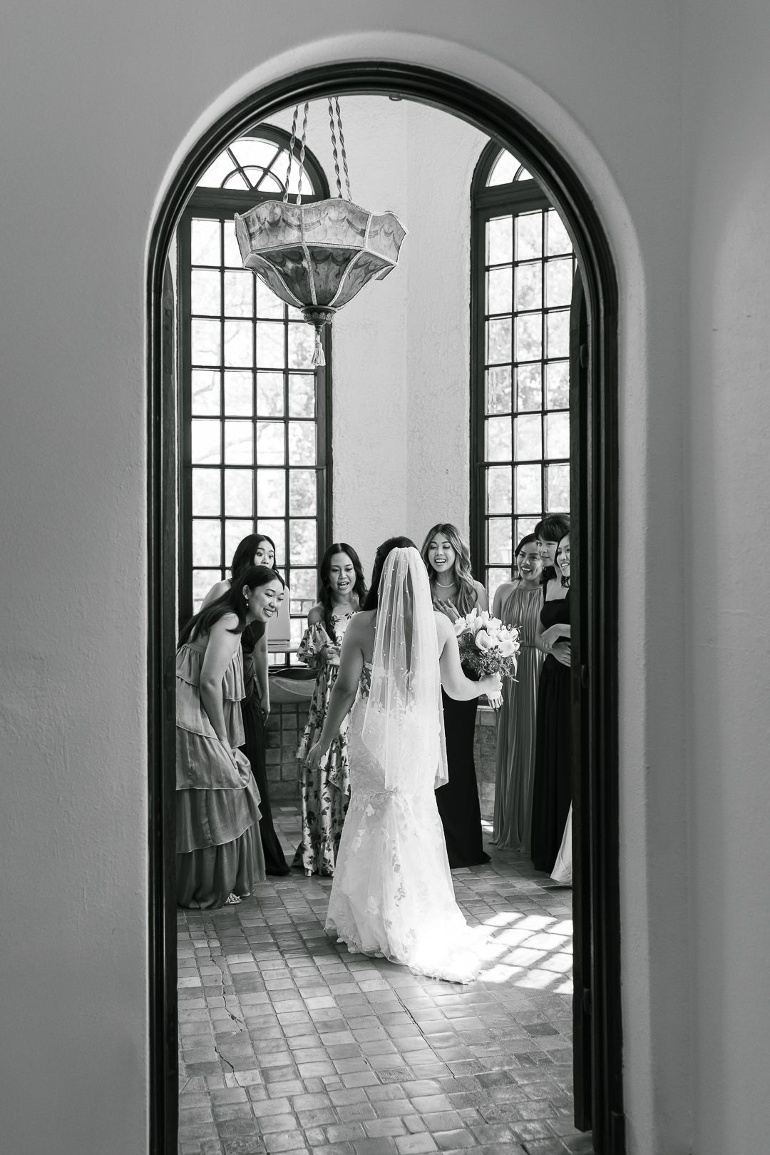Black and white photo sequence showing a wedding ceremony through arched doorways in an elegant interior space.