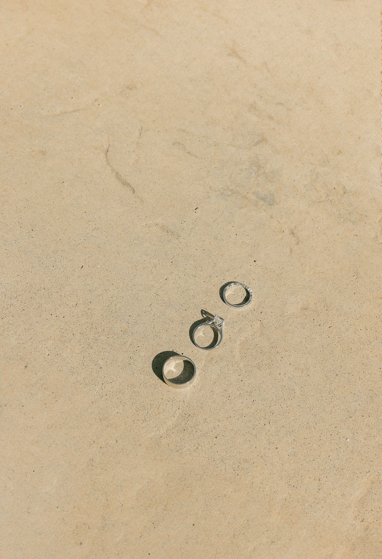 Four sequential images showing a water drop casting a circular shadow on a beige textured surface.