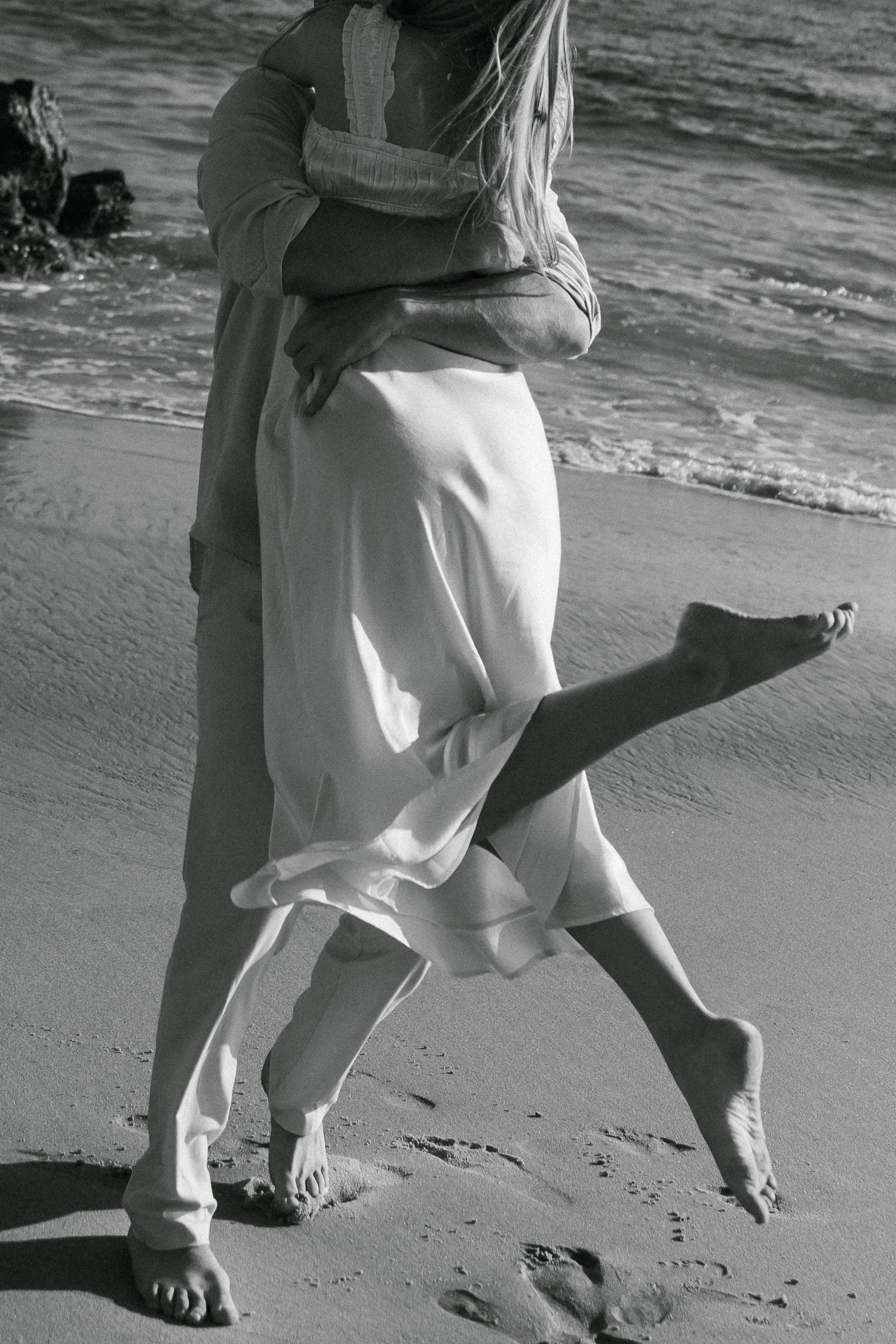 Black and white series of photos showing feet dancing on a sandy beach with waves in the background.
