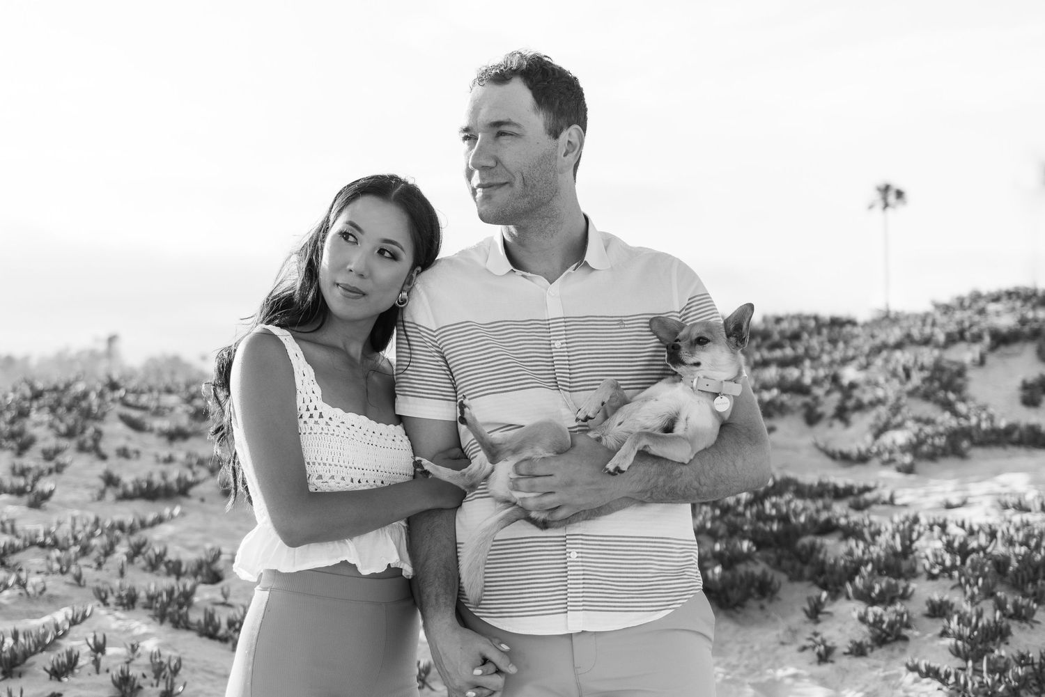 A couple shares intimate moments in a series of black and white photos on a beach.