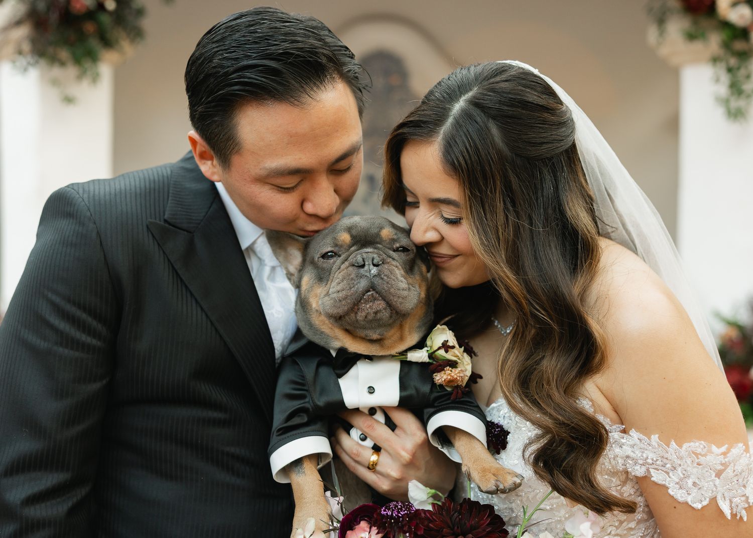 A couple shares an intimate moment with their cat during their wedding ceremony.