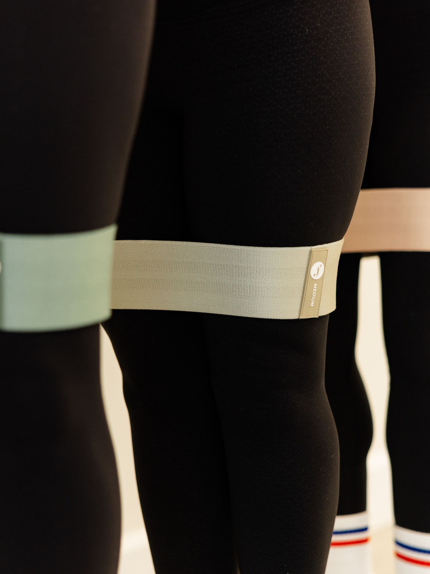 Close-up of black leggings with white reflective bands and striped athletic socks.