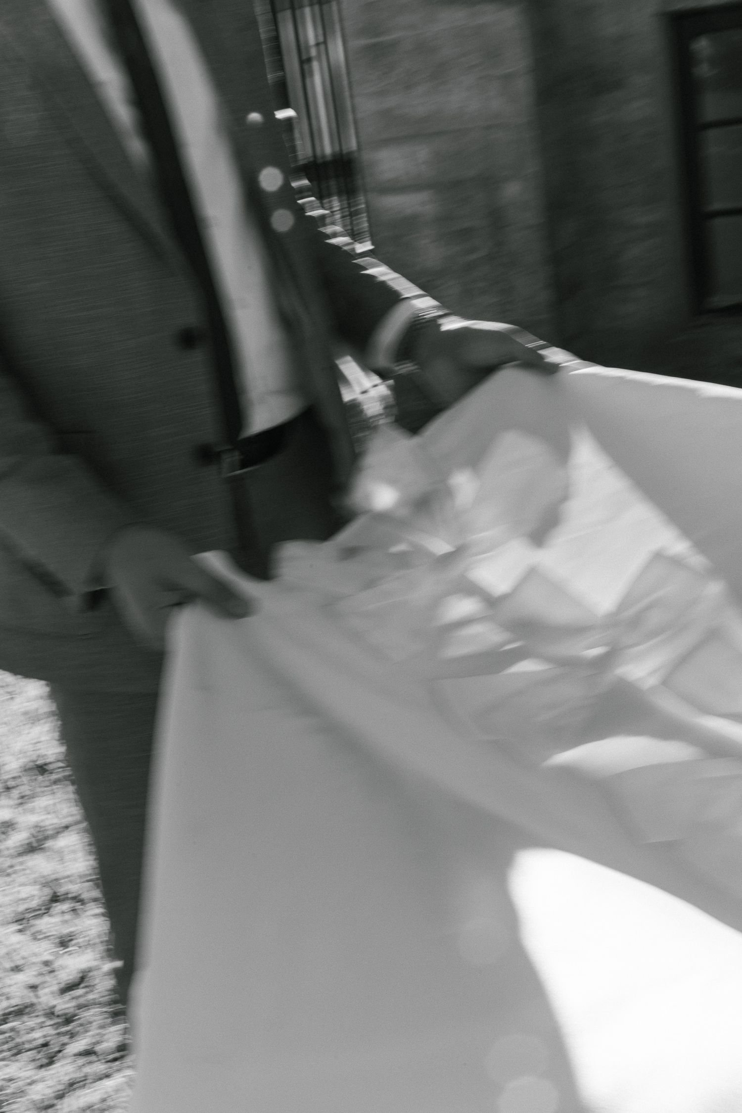 A blurry black and white photograph of dress fabric resting on a carpeted floor.