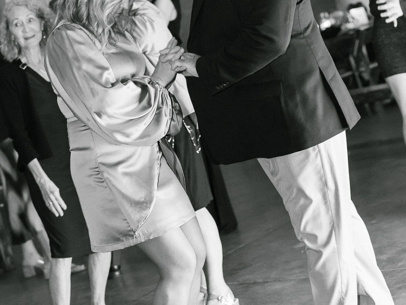 Black and white photo of dancers enjoying themselves on a reception dance floor.