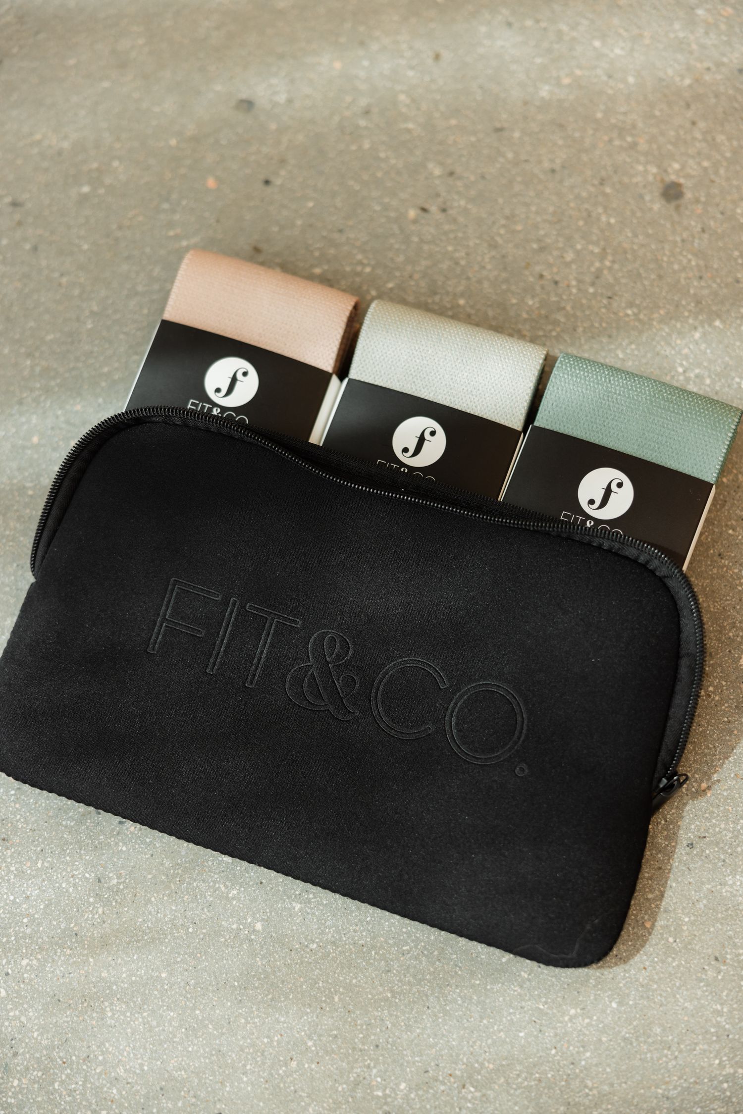 Black leather Filco keyboard wrist rest shown from multiple angles on a light concrete surface.