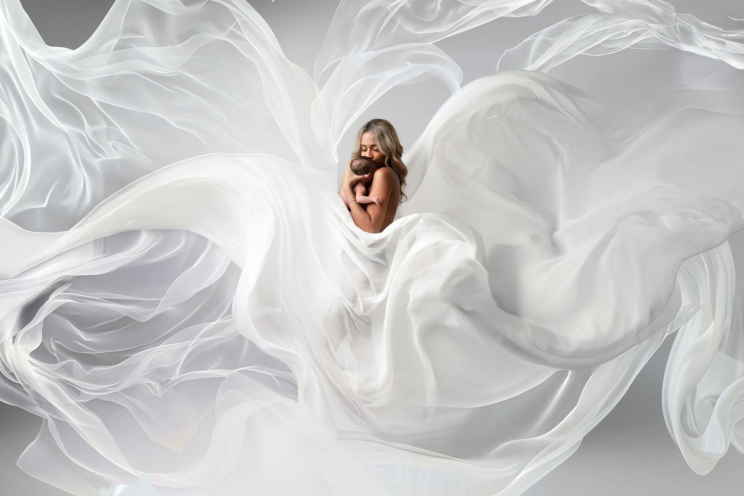 A flowing white silk fabric with elegant curves and folds creates an ethereal abstract pattern against a dark background.