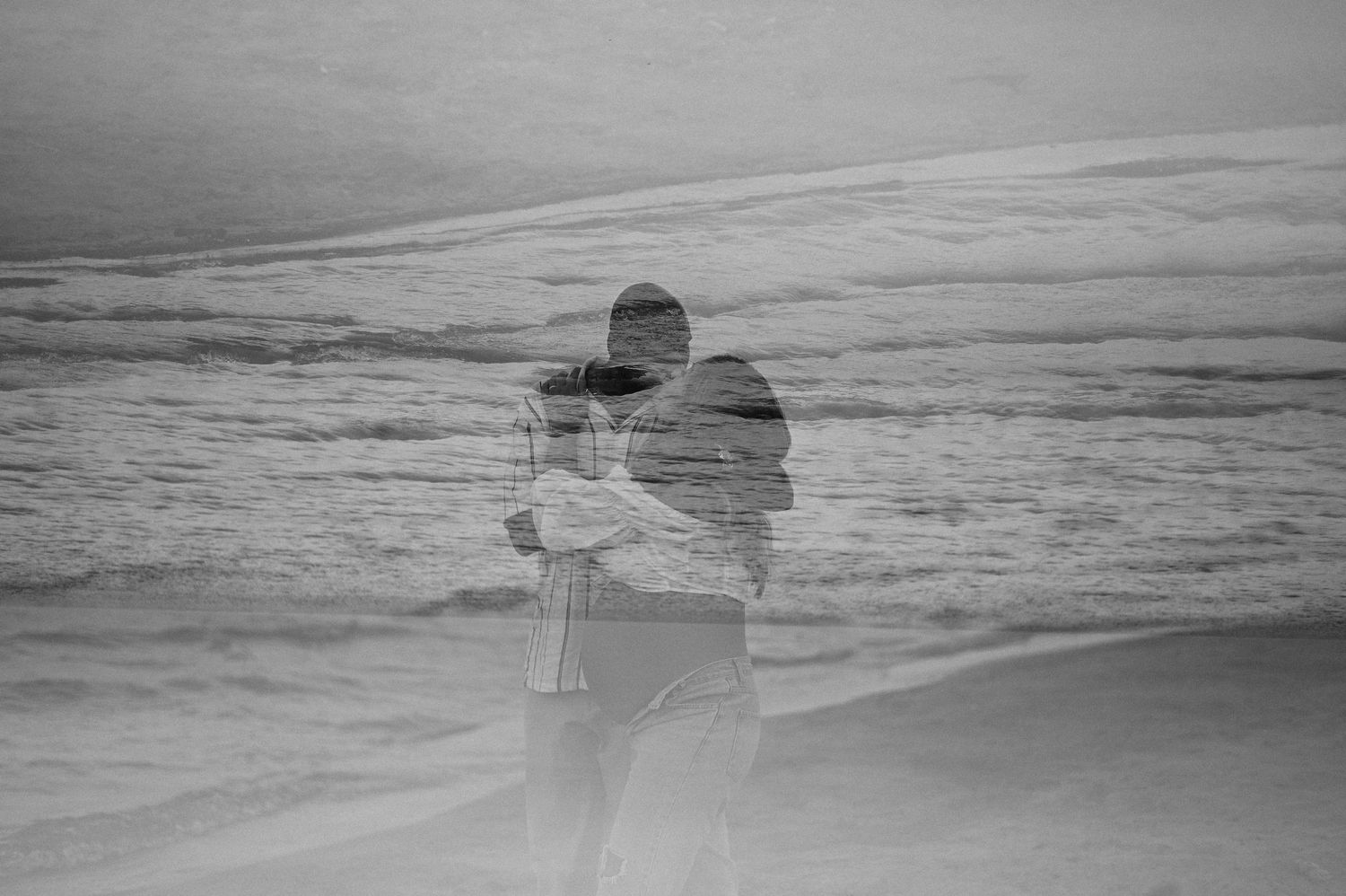 Double exposure black and white silhouette on a beach with waves in the background.