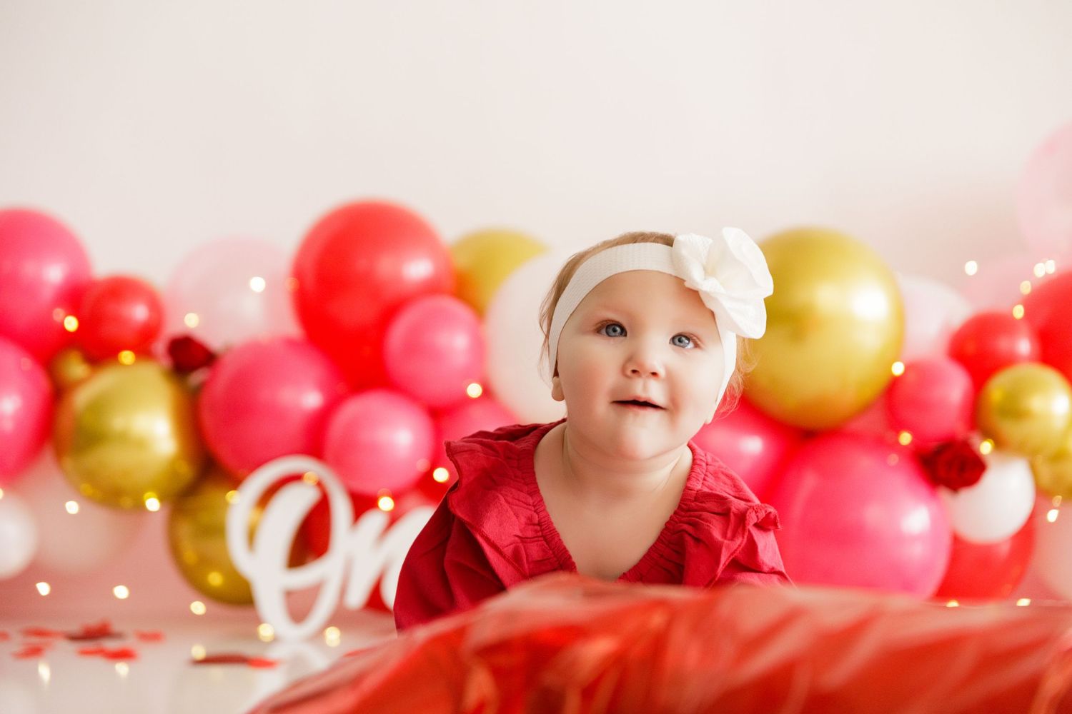 Festive pink, red and gold balloon garland creates a romantic Valentine's Day backdrop.