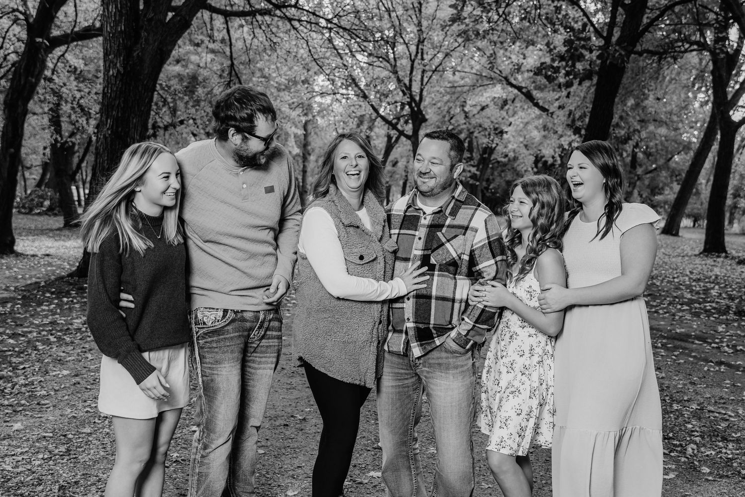 Black and white portrait of a group sharing joyful moments in an outdoor setting.