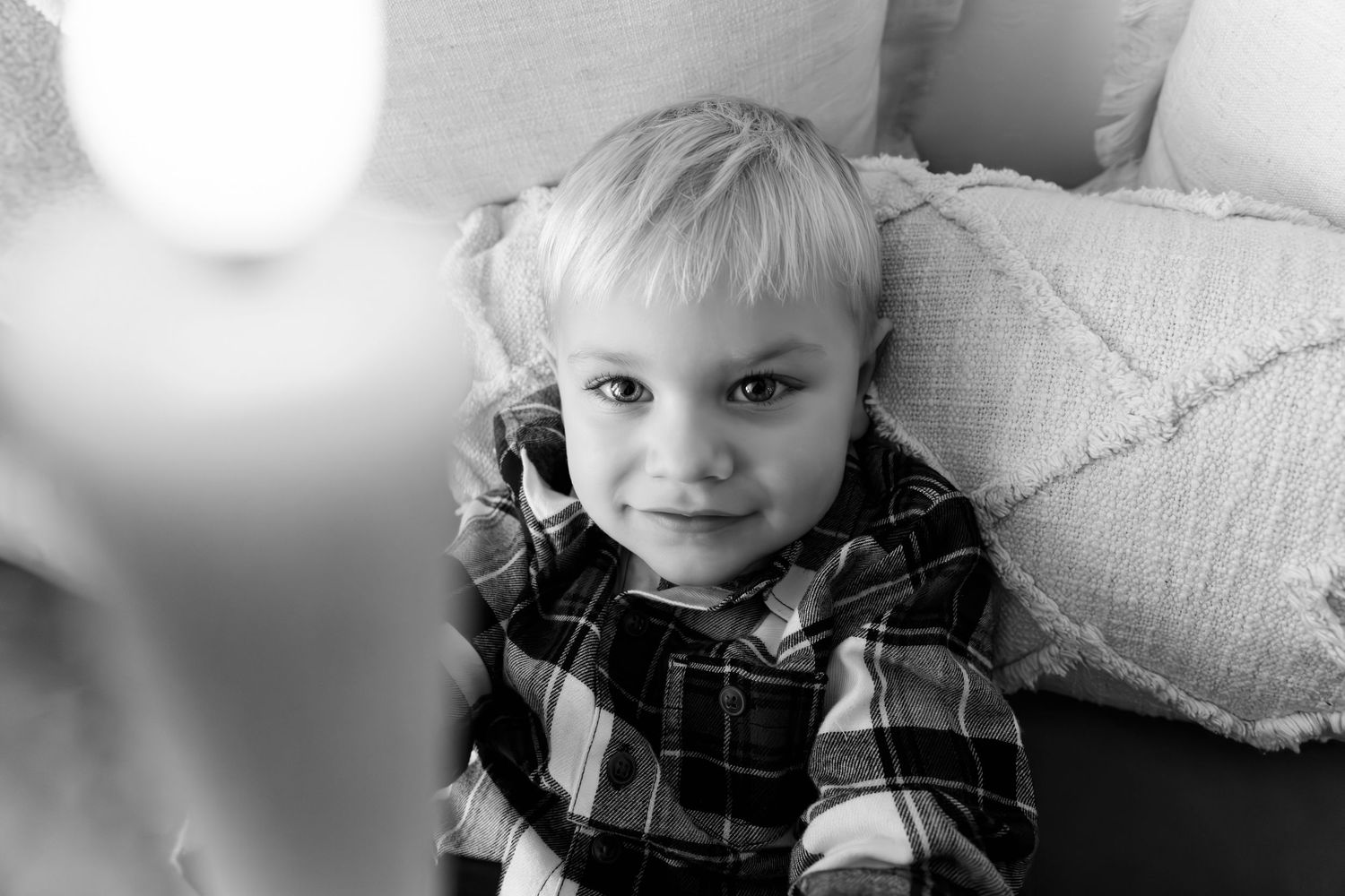 Close-up portrait with warm candlelight creating gentle bokeh effect in background.