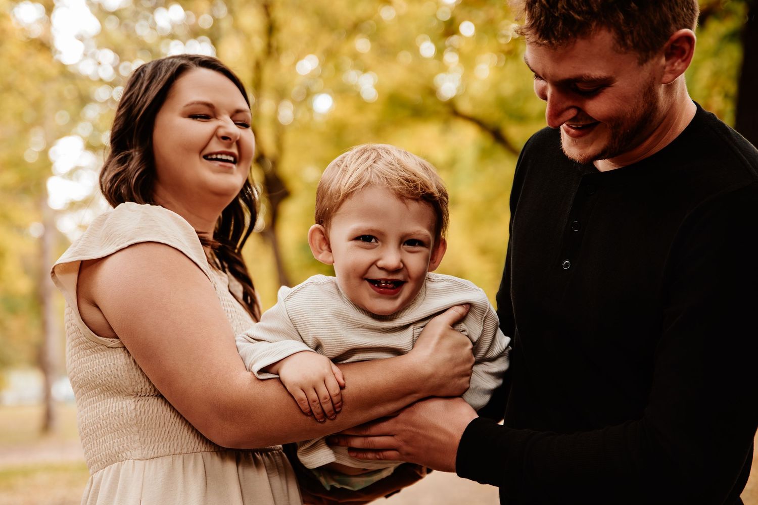 Golden hour family photoshoot in a park with warm autumn lighting.