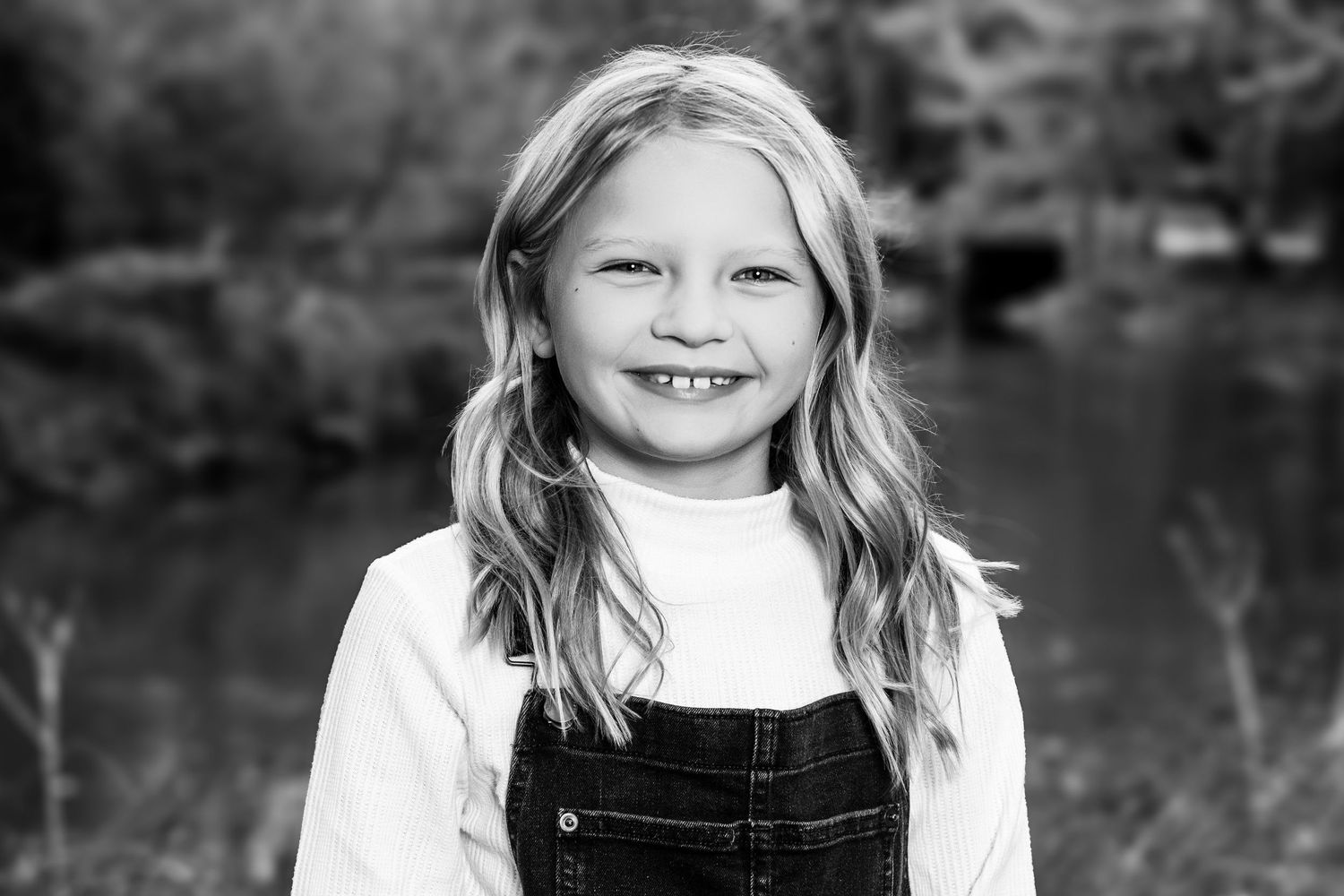 A series of black and white portraits showing joyful expressions and natural outdoor settings.