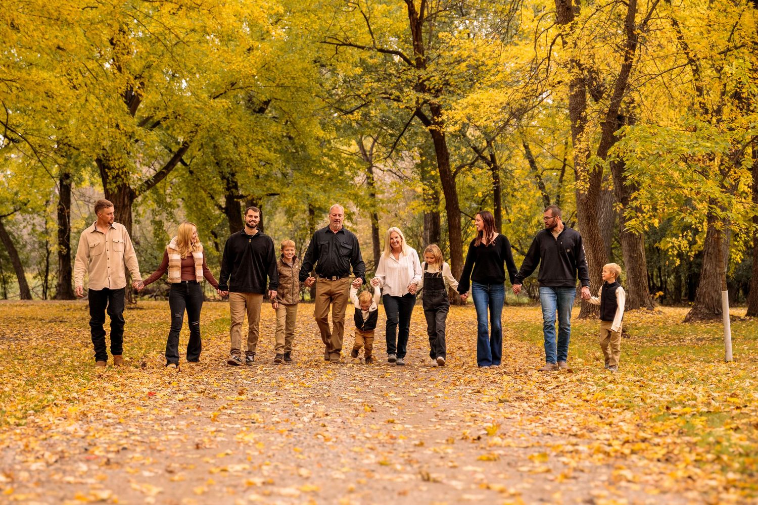 Group walking together through a park with golden fall foliage in the background.