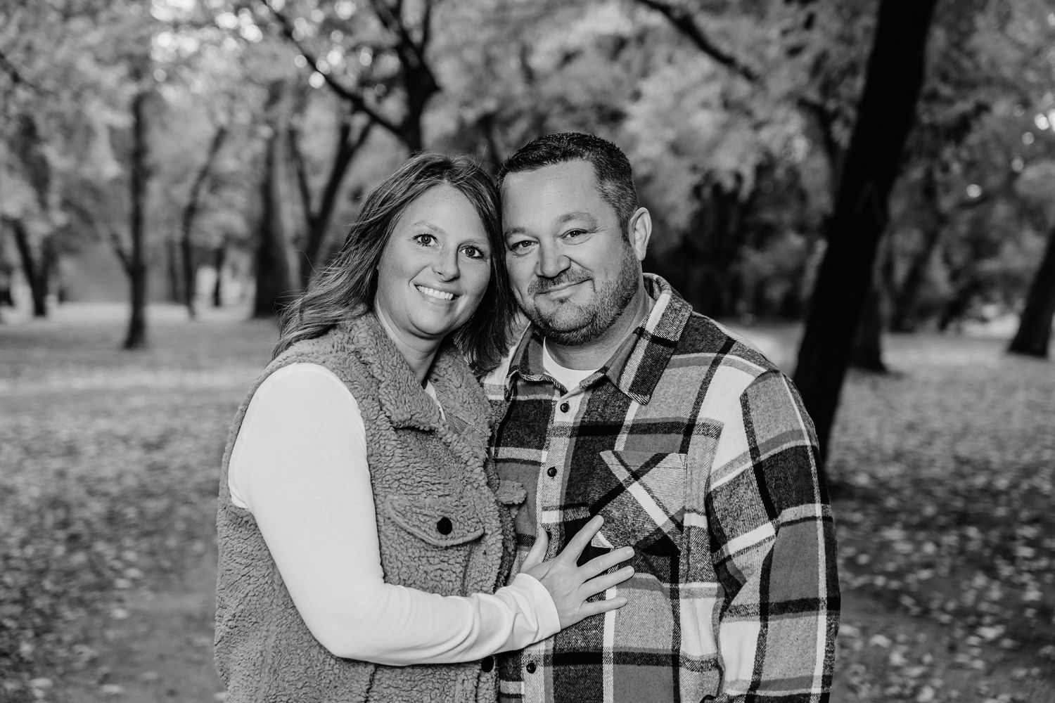 Black and white candid portrait capturing intimate moments in a park setting.