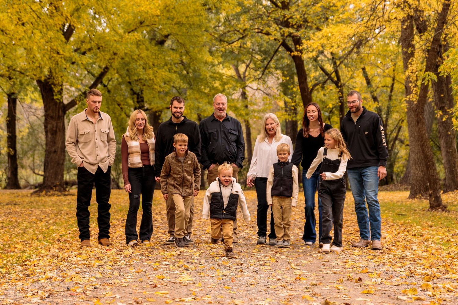 Large group portrait of family members lined up in fall foliage.