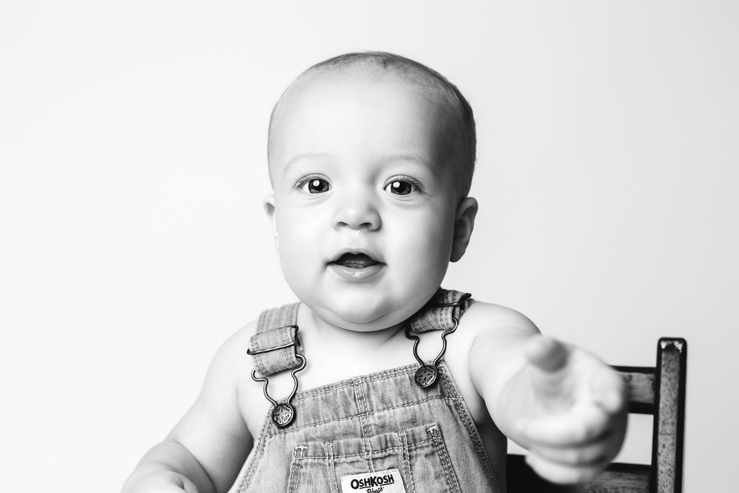 A black and white photo sequence shows a baby in overalls making various playful expressions.