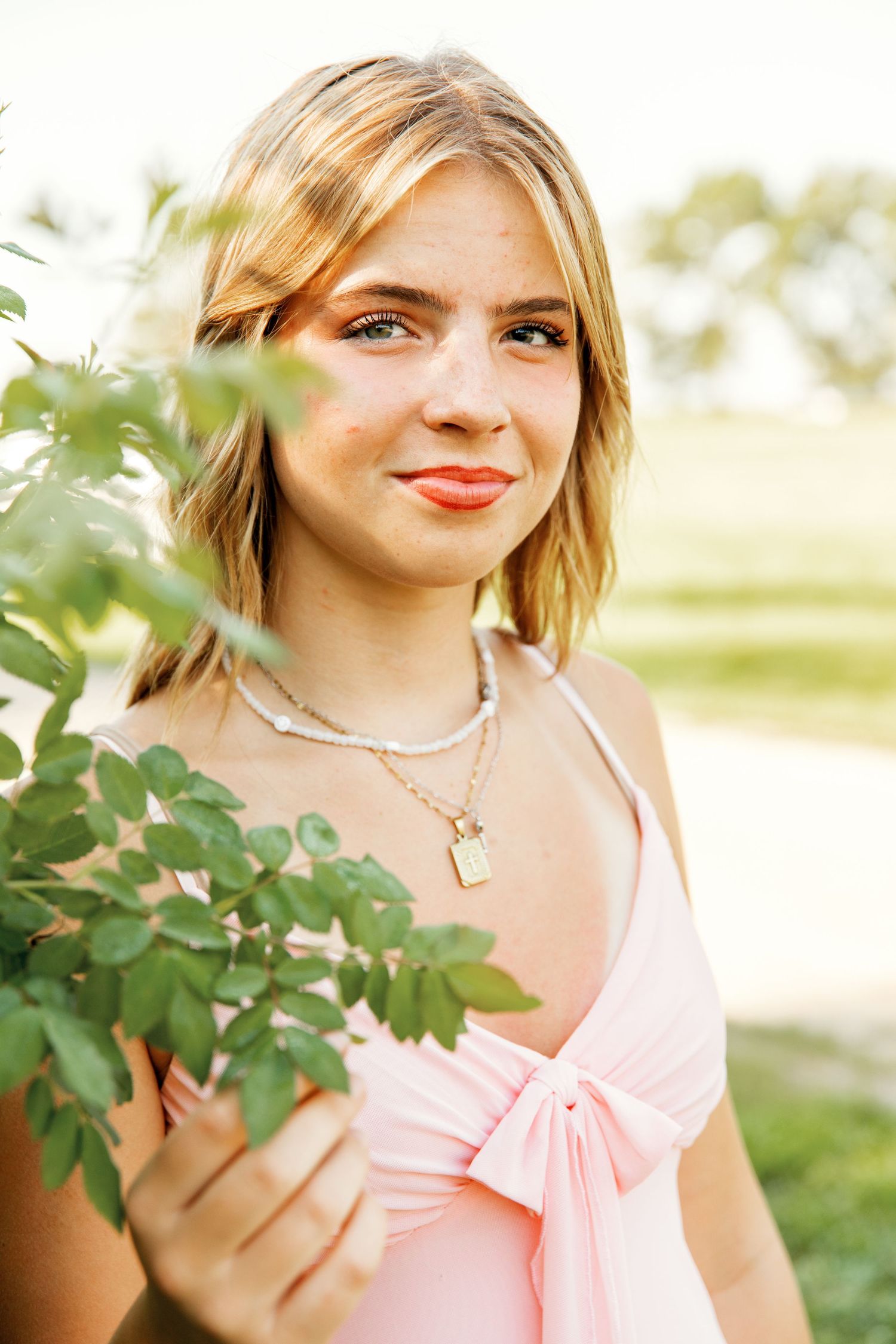 Portrait series showing close-up shots with pink clothing and green foliage in natural lighting.