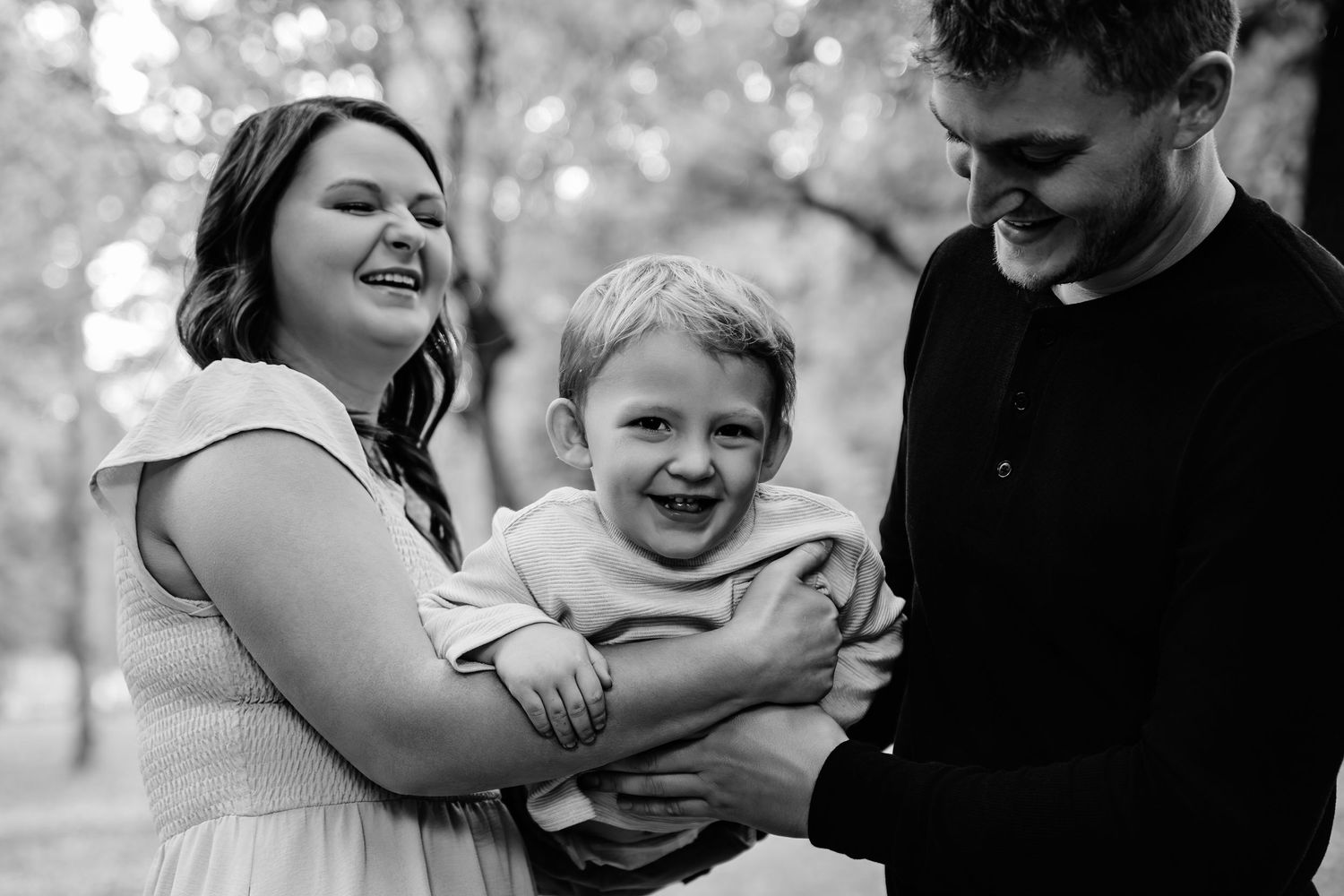 Intimate family moment captured in black and white during outdoor photo session.