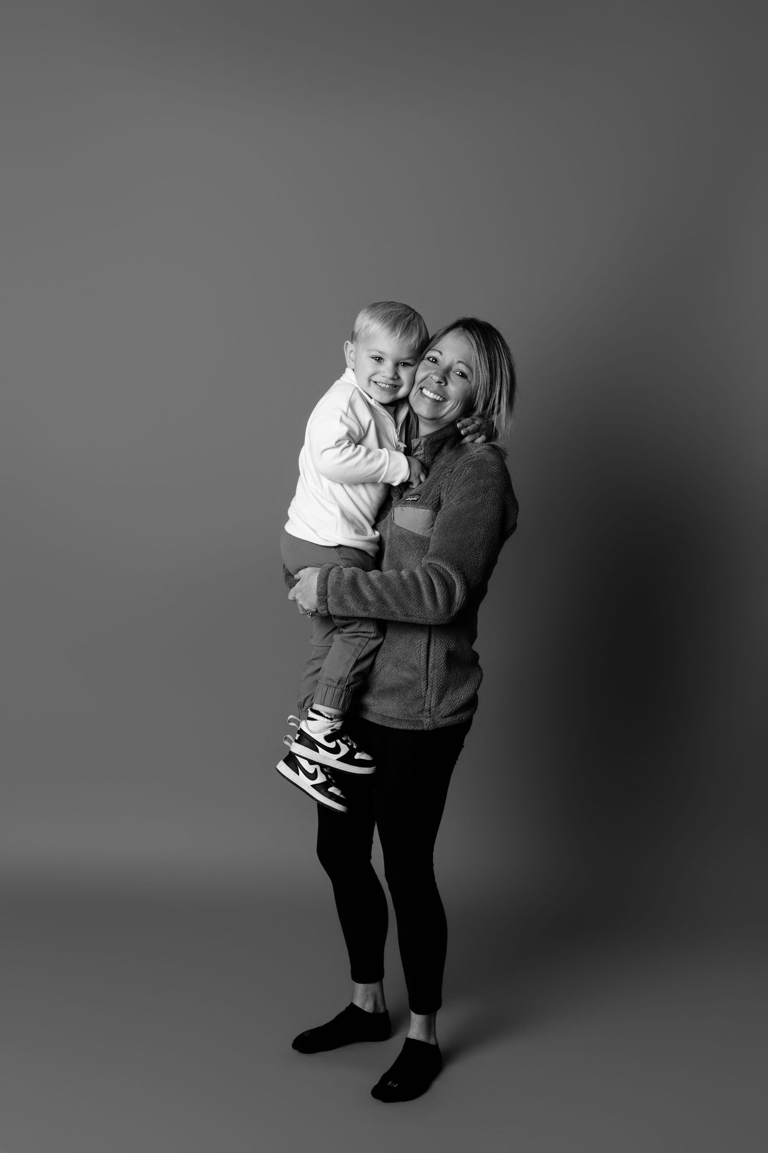 Black and white studio portraits showing embraces and joyful interactions.