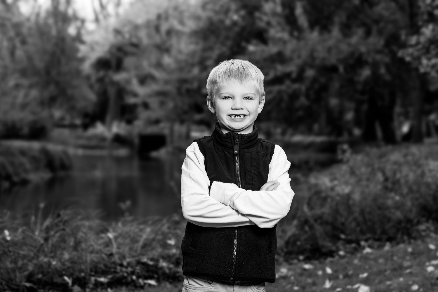 Black and white portraits of children in casual attire against a natural outdoor background.