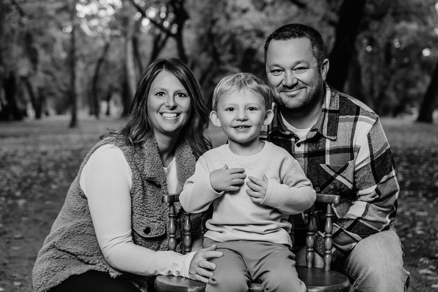 Black and white family portrait captured outdoors during a fall photoshoot.