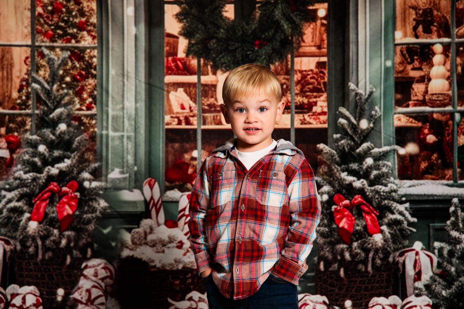 Seasonal portrait session featuring plaid shirt among decorated Christmas trees and wreaths.