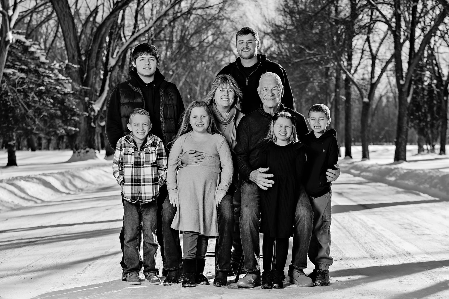 A black and white portrait of a group standing together in a snowy winter landscape.