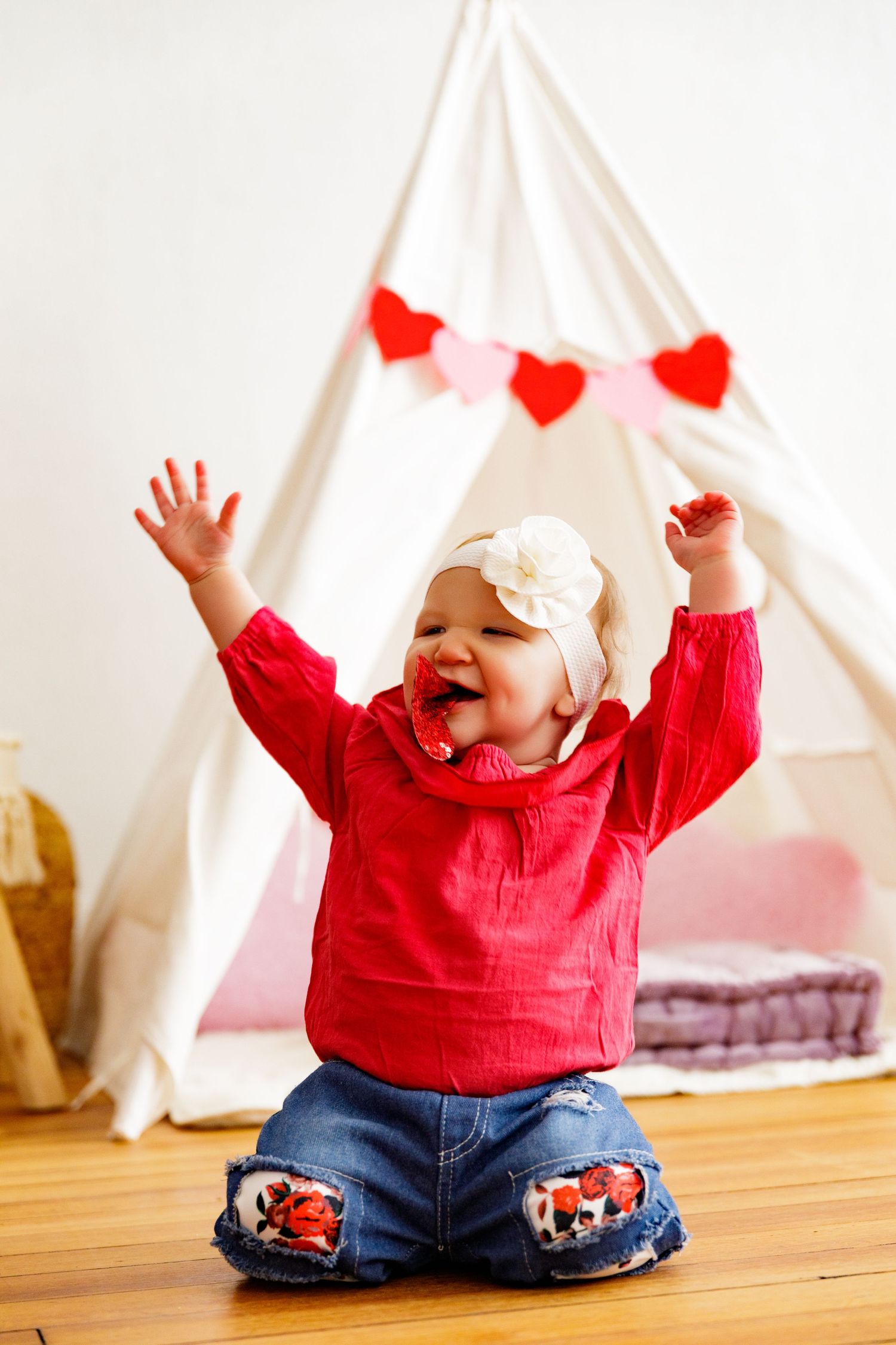 Red and white Valentine's themed setup with teepee and heart decorations.